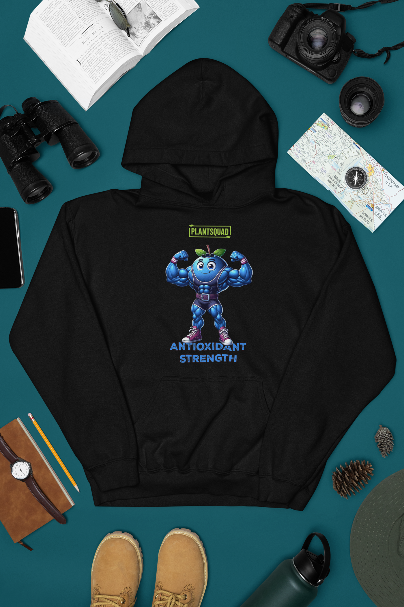 Introducing the Plantsquad Blueberry "Antioxidant Strength" - Unisex Hoodie: a black hoodie showcasing a muscular blue blueberry cartoon, flexing its arms and donned with a belt. Perfect for gym enthusiasts embracing the vegan lifestyle, it features "PLANTSQUAD" above and "ANTIOXIDANT STRENGTH" below the vibrant image.