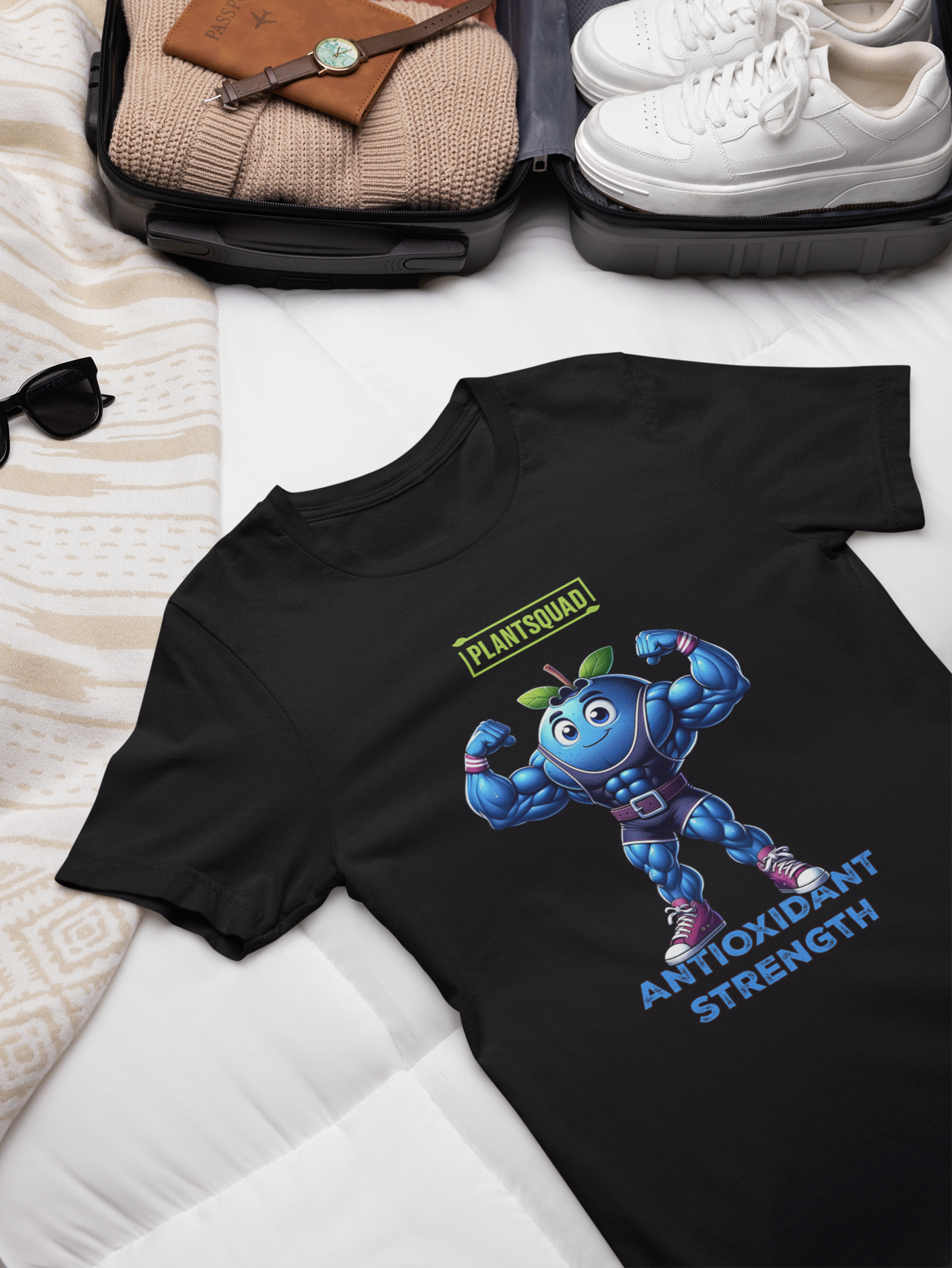 A Plantsquad Blueberry "Antioxidant Strength" - Unisex T-Shirt featuring a muscular cartoon blueberry character flexing its arms. Above the character, "PLANTSQUAD" is boldly written, and below, "ANTIOXIDANT STRENGTH" shines in blue.