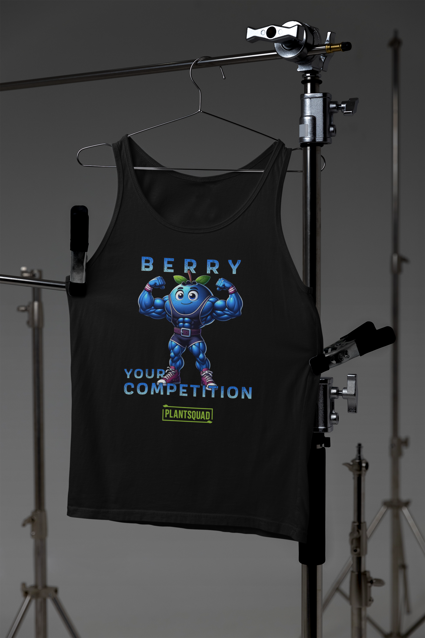 The Plantsquad Blueberry "Berry Your Competition" - Unisex Tank Top for gym enthusiasts features a muscular cartoon blueberry character flexing its arms. Above the character, text reads "BERRY," and below the character, text reads "YOUR COMPETITION." Made from breathable fabric, it also includes a green and yellow "PLANTSQUAD" logo at the bottom.