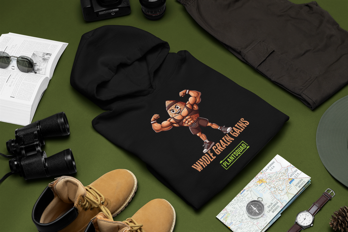 This black vegan hoodie, the Plantsquad Brown Rice "Whole Grain Gains" - Unisex Hoodie, features a cartoon image of a muscular grain character flexing its arms. The text reads "WHOLE GRAIN GAINS" above the character and "PLANTSQUAD" below it, making it perfect gym wear for those embracing a plant-based lifestyle.