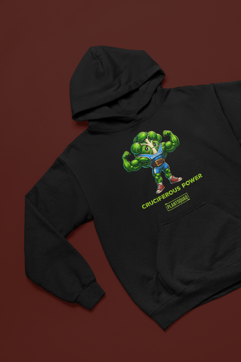 The Plantsquad Brussel Sprout "Cruciferous Power" - Unisex Hoodie features a muscular Brussels sprout character flexing its biceps. The text below the character reads "CRUCIFEROUS POWER" and "PLANT SQUAD." The sprout wears sneakers and shorts, emphasizing strength and health, making it perfect weight lifting apparel for a plant-based lifestyle.