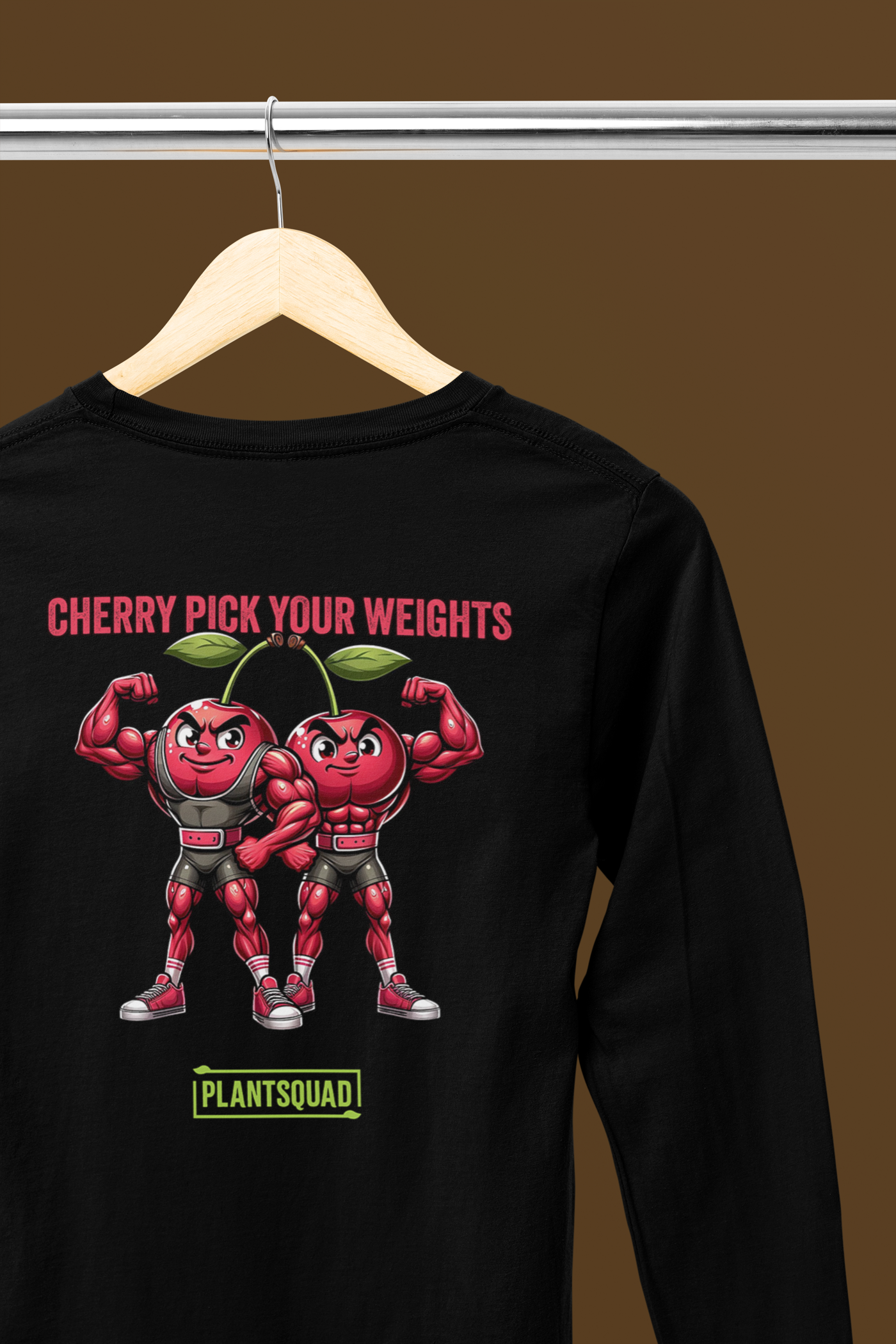 A black long-sleeve shirt featuring two muscular, flexing cherries wearing shorts and shoes. Above them, the text reads "CHERRY PICK YOUR WEIGHTS" in red, and below them, "PLANTSQUAD" is written in green. The cherries have confident expressions—perfect workout apparel for fitness enthusiasts embracing a vegan lifestyle. This is the Plantsquad Cherries "Cherry Pick Your Weights" - Unisex Long Sleeve T-Shirt.