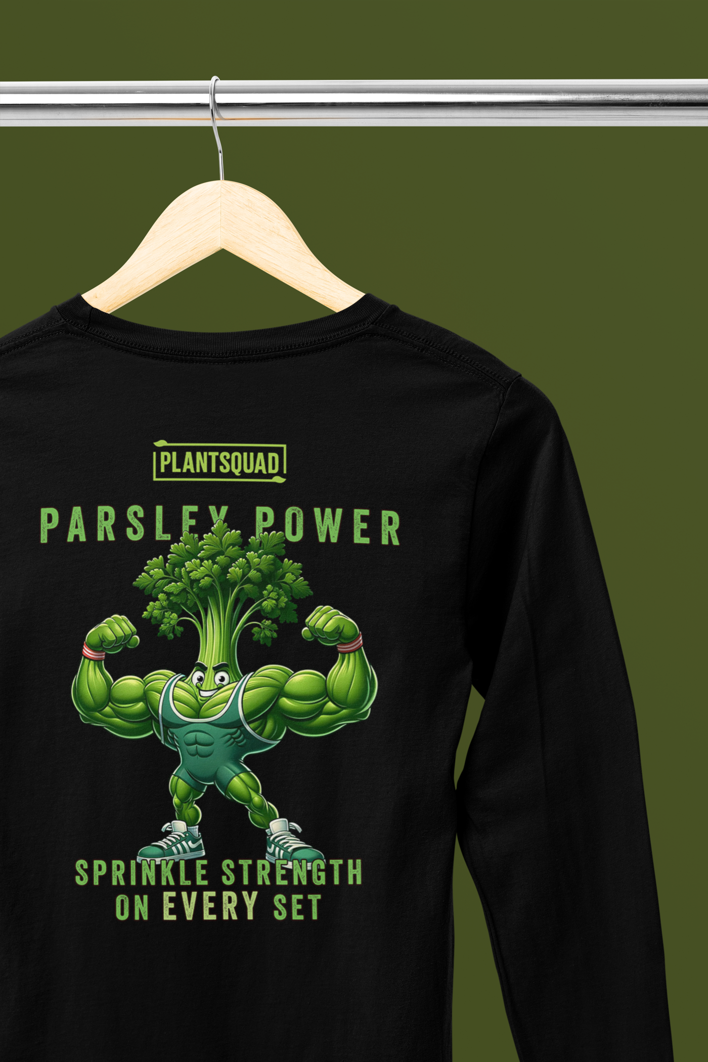 The Plantsquad Parsley "Parsley Power Sprinkle Strength On Every Set" - Unisex Long Sleeve T-Shirt features a muscular cartoon parsley character flexing its arms. The text above the character reads "PLANTSQUAD" and "PARSLEY POWER," and below it says "SPRINKLE STRENGTH ON EVERY SET." Perfect for fitness enthusiasts embracing a vegan lifestyle.