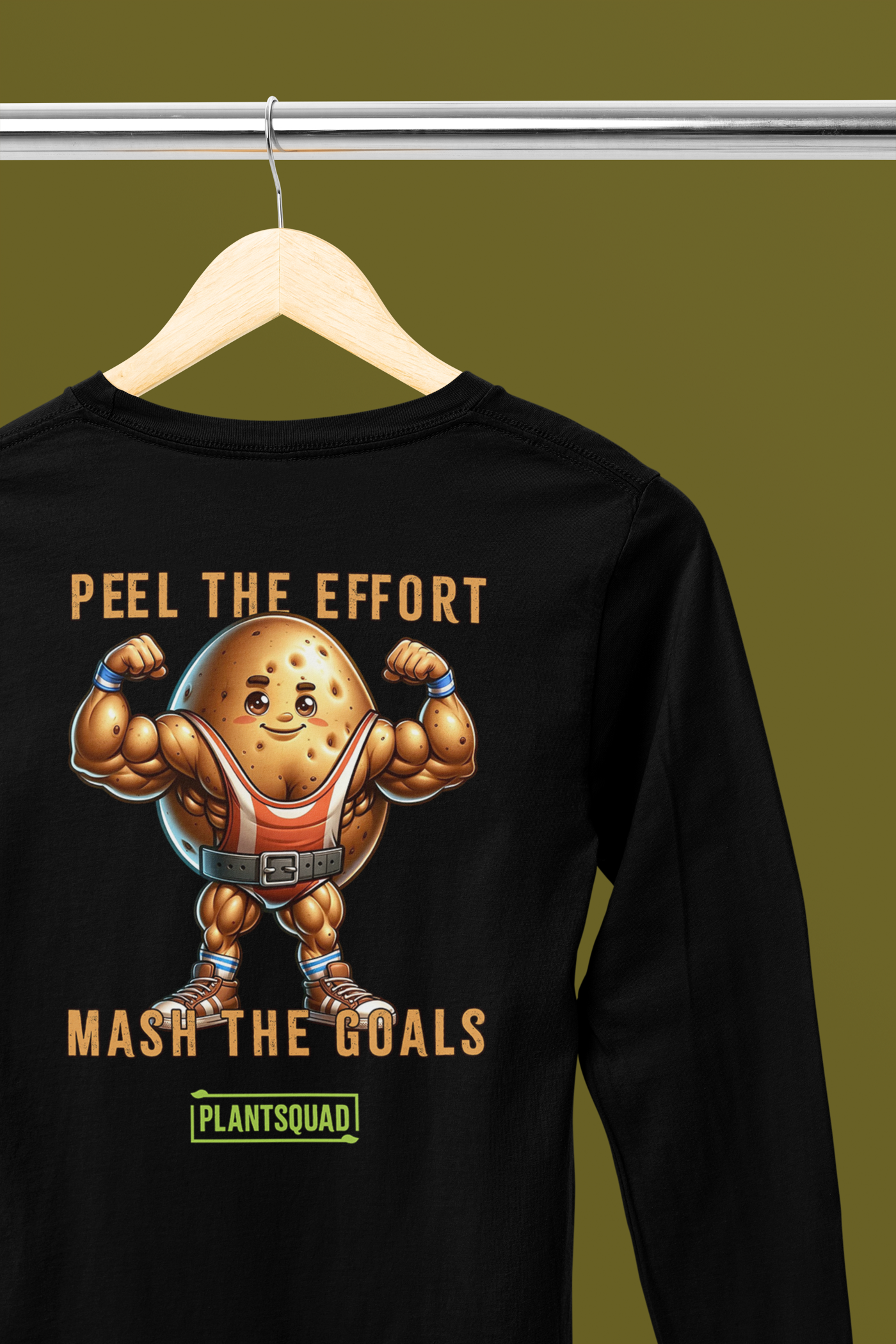 A black long-sleeve shirt features a muscly potato cartoon flexing its arms. Above it is the text "Peel the Effort," and below it reads "Mash the Goals." Embrace a plant-based lifestyle with this fun design, complete with a green label at the bottom reading "PLANTSQUAD." This is available as the Plantsquad Potato "Peel The Effort Mash The Goals" - Unisex Hoodie.