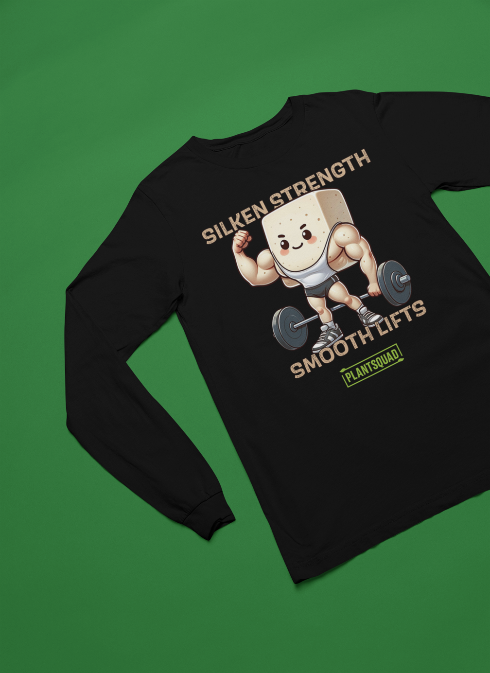 A Plantsquad Tofu "Silken Strength Smooth Lifts" - Unisex Long Sleeve T-Shirt features a muscly tofu cartoon lifting weights. Above the graphic, text reads "SILKEN STRENGTH" and below reads "SMOOTH LIFTS." Beneath the tofu, a green and yellow logo displays "PLANTSQUAD," making it perfect for fitness enthusiasts embracing a vegan lifestyle.