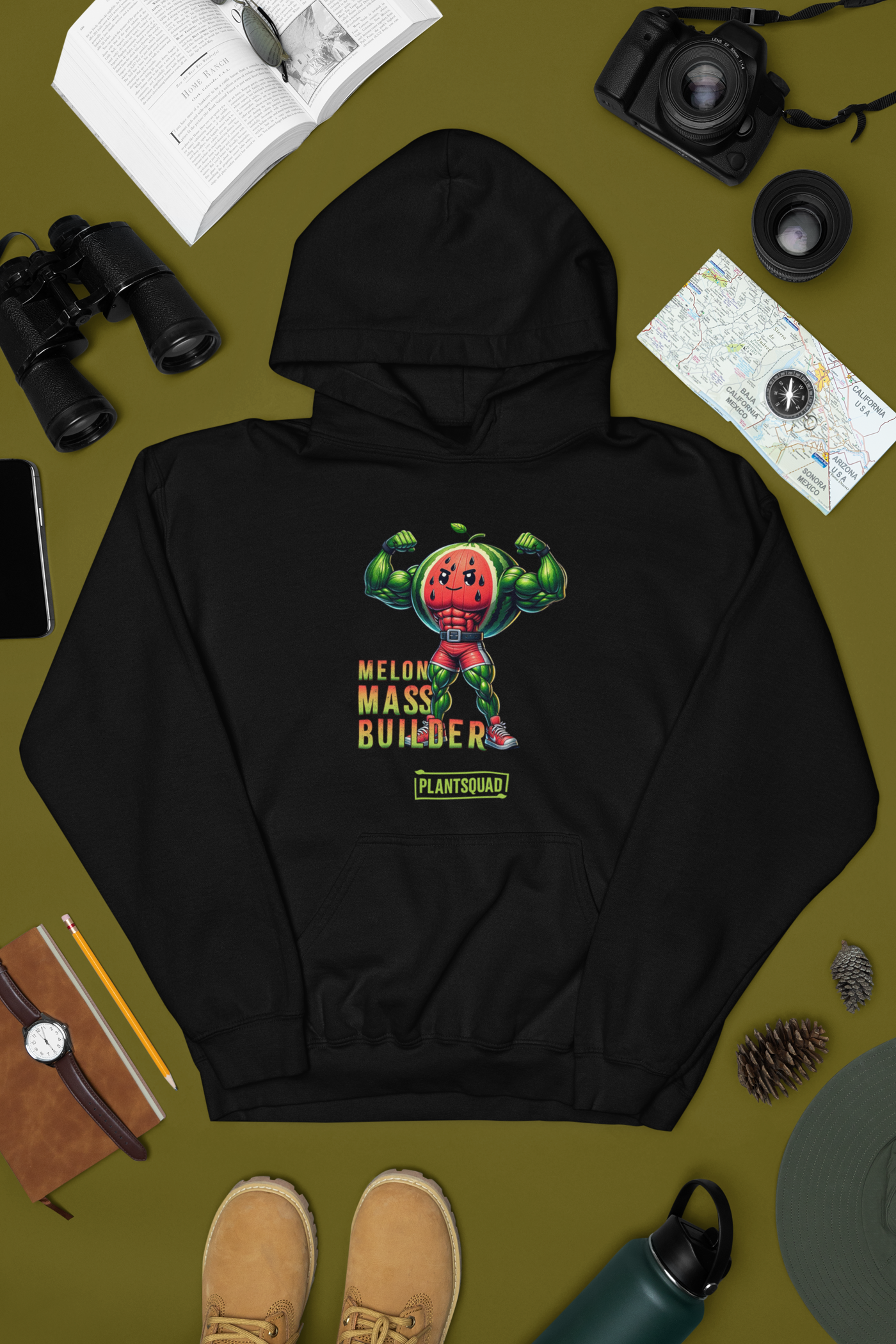 The Plantsquad Watermelon "Melon Mass Builder" - Unisex Hoodie features an illustration of a muscular watermelon character flexing its arms. The text reads "Melon Mass Builder" above and "Plant Squad" below. Made from cozy fabric, it's perfect for those embracing a vegan lifestyle with a pop of red, green, and yellow colors.