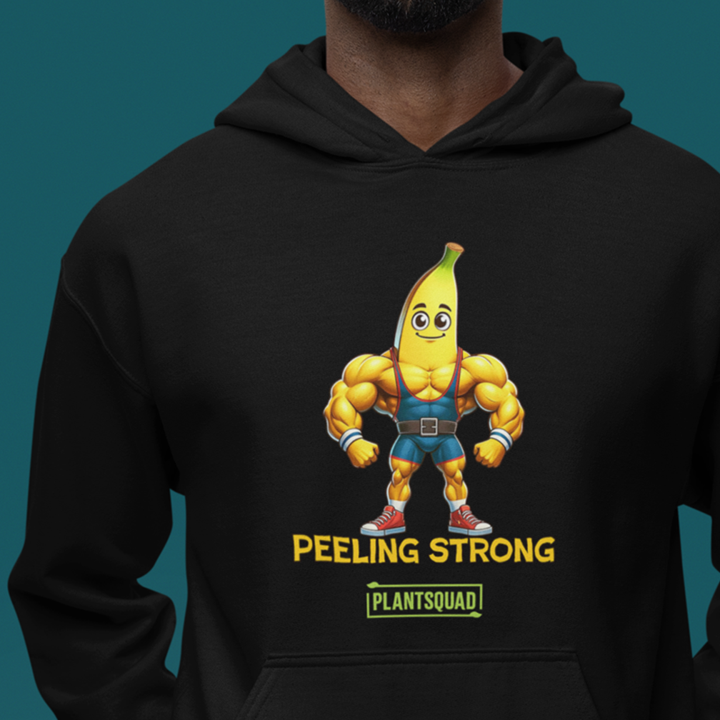 A person wearing a black hoodie with a graphic of a muscular, anthropomorphic banana lifting weights. The text on the hoodie reads "PEELING STRONG" above "PLANTSQUAD". The background is a solid teal color.