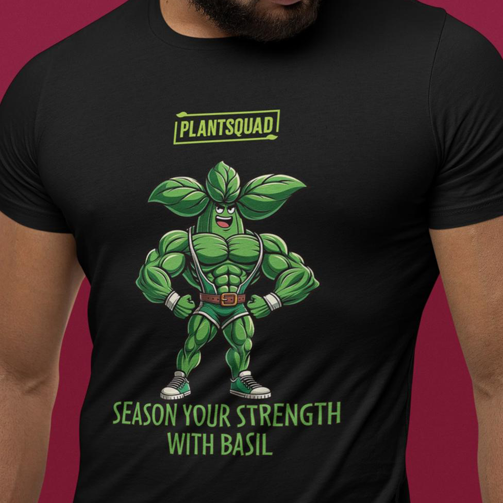 A person wearing a black t-shirt with a cartoon of a muscular anthropomorphic basil plant flexing its muscles. Above the character is the text "PLANTSQUAD!" and below it reads, "SEASON YOUR STRENGTH WITH BASIL.