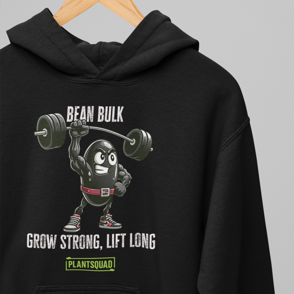 A black hoodie hangs against a grey background. The hoodie features a cartoon bean character lifting a barbell, with text above stating "BEAN BULK" and below saying "GROW STRONG, LIFT LONG." The bottom has a "PLANTSQUAD" logo in green and white.