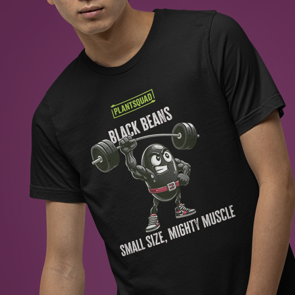 A person is wearing a black T-shirt featuring an illustration of a black bean lifting a barbell with the text "PLANTSQUAD BLACK BEANS" above the illustration, and "SMALL SIZE, MIGHTY MUSCLE" below. The background is a gradient of dark and light purple.