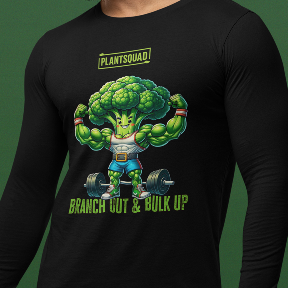 A person is wearing a black long-sleeve shirt with a design of a muscular broccoli lifting weights. The text on the shirt reads "PLANTSQUAD" at the top, and "BRANCH OUT & BULK UP" at the bottom. The background is a solid green color.