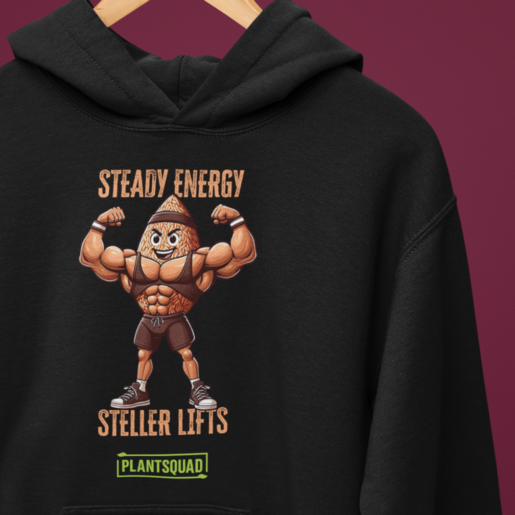 Black hoodie on a hanger with a graphic of a muscular anthropomorphic almond flexing its arms. Text above reads "STEADY ENERGY", and below reads "STEADY LIFTS". At the bottom, a green label says "PLANTSQUAD". Background is maroon.