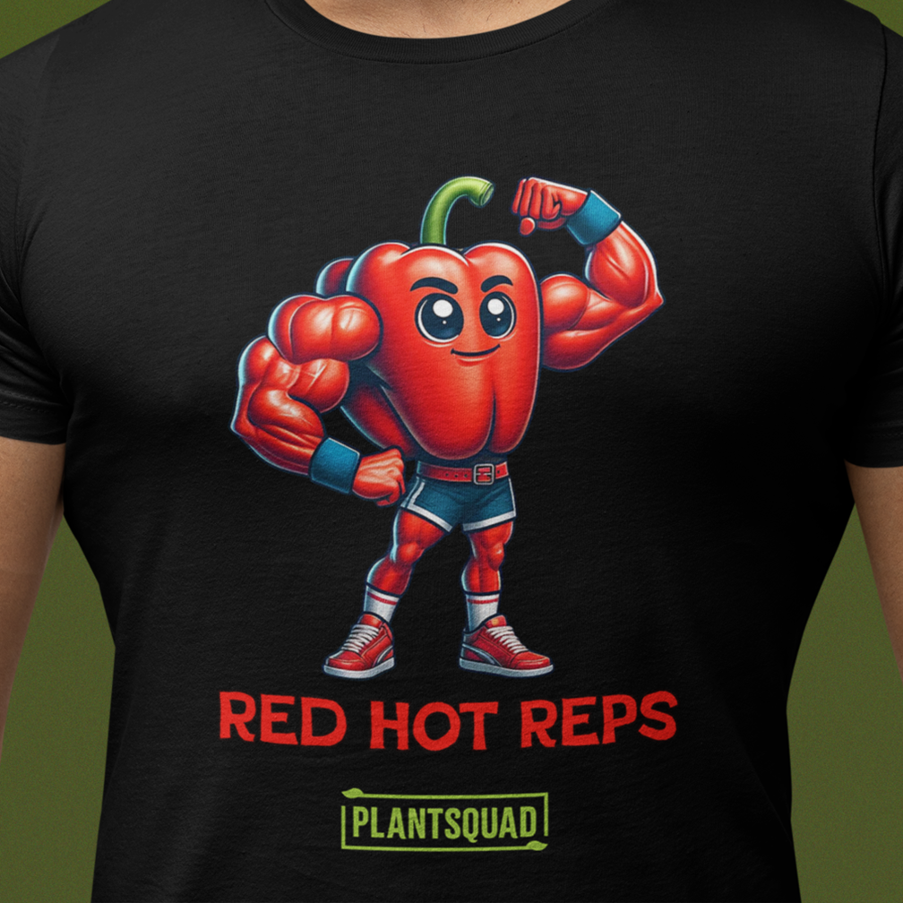 A person is wearing a black T-shirt with a graphic of a muscular red bell pepper character flexing its biceps. The text below reads, "RED HOT REPS" and "PLANTSQUAD" in red and green letters, respectively.