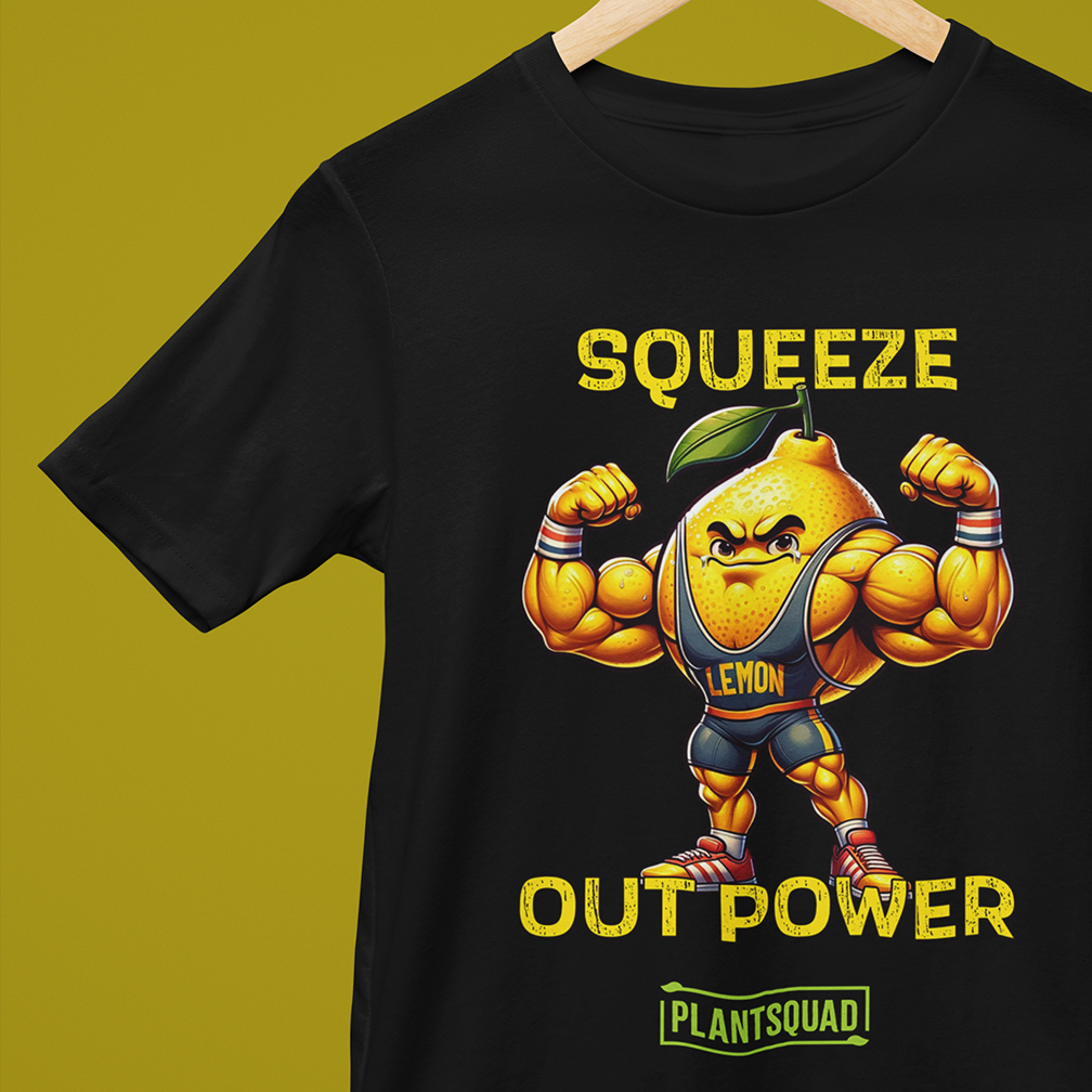 A black T-shirt with an illustration of a muscular lemon flexing its arms. It wears a sleeveless shirt labeled "LEMON" and sneakers. Above the lemon, text reads "Squeeze Out Power," with "PlantSquad!" written below. The background is olive green.