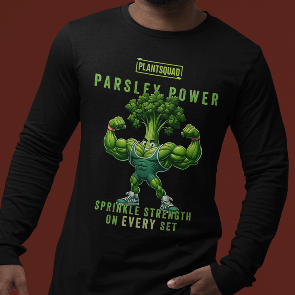 A person wearing a black long-sleeve shirt with an illustration of a muscular parsley character flexing its arms. The text on the shirt reads "Plantsquad Parsley Power" and "Sprinkle Strength on Every Set.