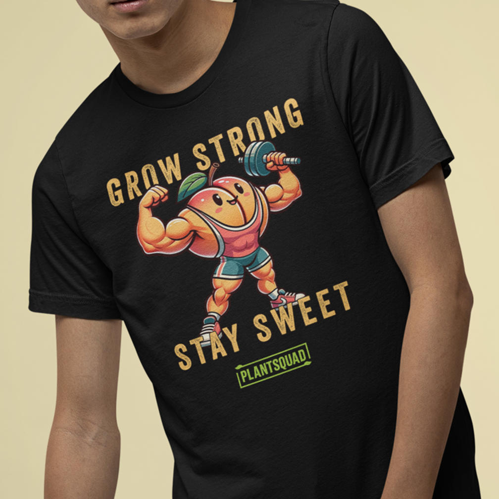 A person wearing a black t-shirt with a cartoon image of a muscular peach lifting a barbell. The text on the shirt reads "Grow Strong, Stay Sweet" and "Plantsquad".