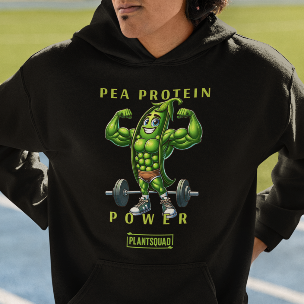 A person wearing a hoodie with a graphic of a muscular cartoon pea pod lifting weights. The text on the hoodie reads, "Pea Protein Power" and "PlantSquad." The background shows an outdoor sports setting with a track.