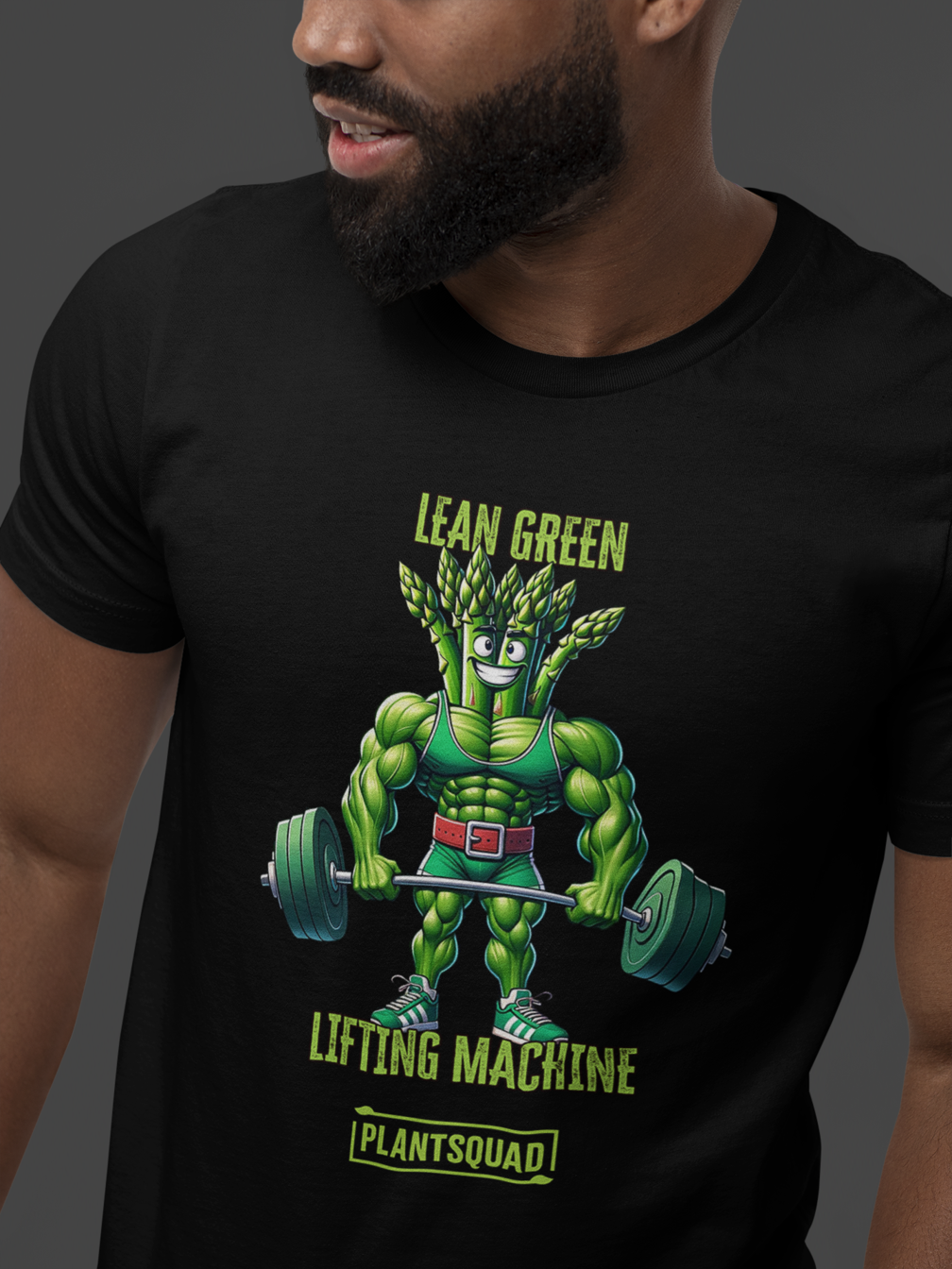 A black T-shirt featuring a muscular green creature holding barbells, under the text "LEAN GREEN LIFTING MACHINE." Below the graphic, a text box proudly reads "Plantsquad Asparagus 'Lean Green Lifting Machine' - Unisex T-Shirt" to represent your team.