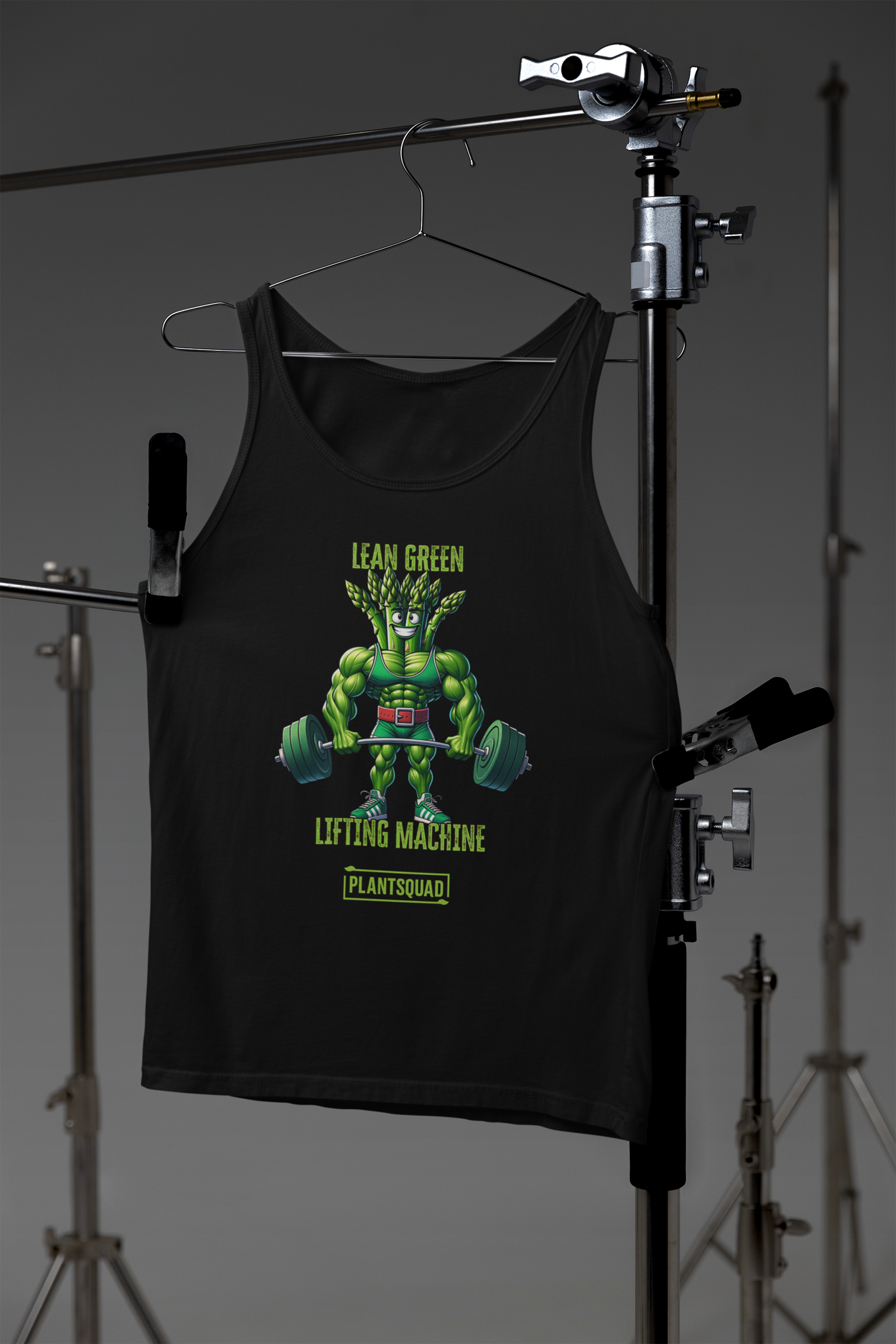 A black vegan Plantsquad Asparagus "Lean Green Lifting Machine" - Unisex Tank Top featuring an illustration of a muscular, green plant-like character lifting a barbell with heavy weights. Above the character is the text "Lean Green Lifting Machine" and below is the text "Plant Squad." Perfect for those embracing a plant-based lifestyle.