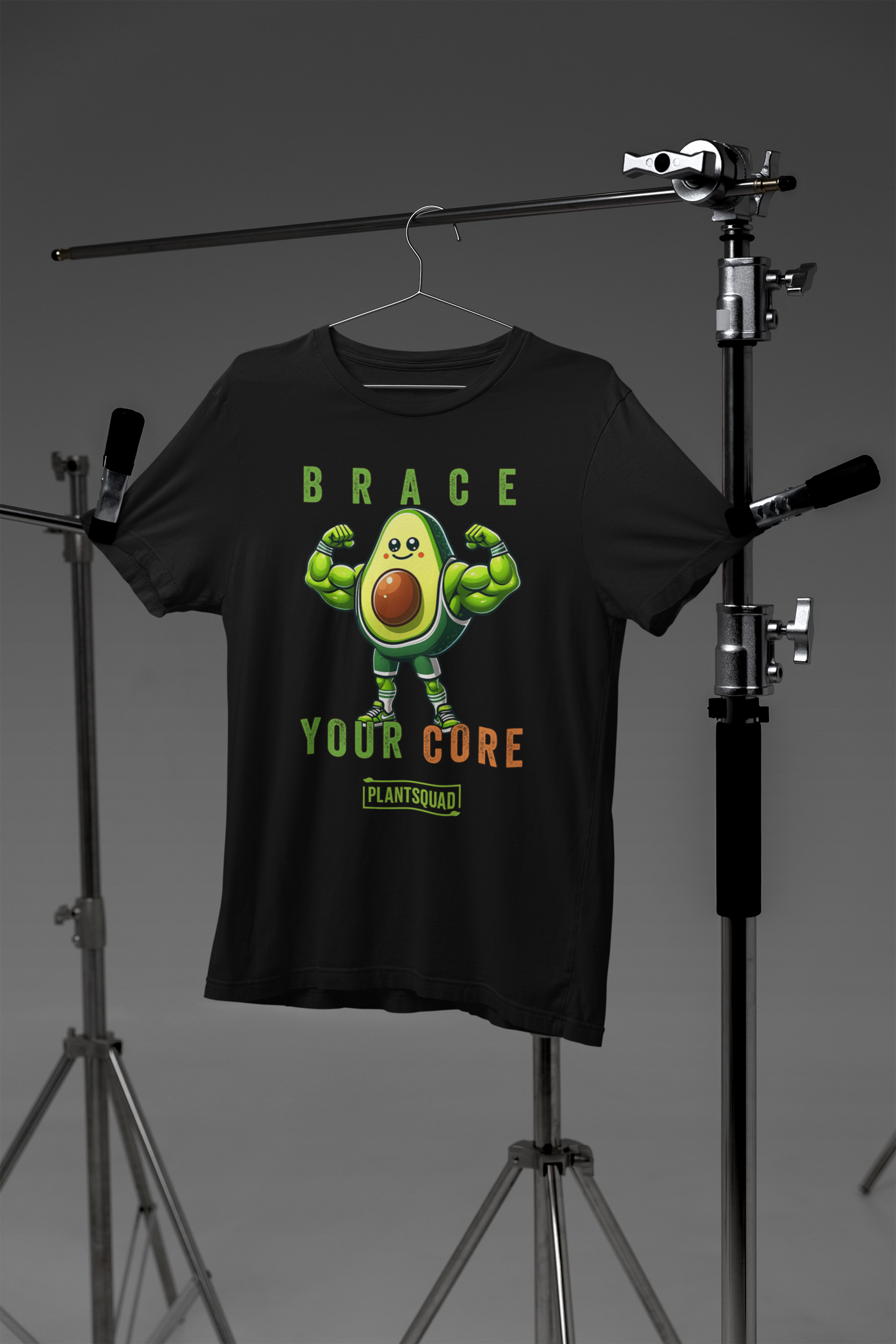 A Plantsquad Avocado "Brace Your Core" - Unisex T-Shirt featuring an illustration of an avocado character with muscular arms and legs, flexing its biceps. Above the avocado are the words "BRACE" and below it, "YOUR CORE." The word "plantsquad" is proudly printed at the bottom.