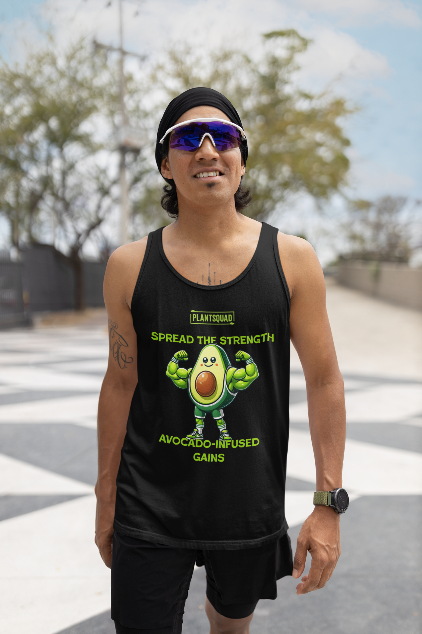 A Plantsquad Avocado "Spread The Strength Avocado-Infused Gains" - Unisex Tank Top featuring a muscly avocado cartoon flexing its arms. Above the avocado, it reads "PLANTSQUAD," while below it says, "SPREAD THE STRENGTH AVOCADO-INFUSED GAINS" in yellow-green letters. Perfect for embracing a plant-based lifestyle and vegan gym wear enthusiasts.