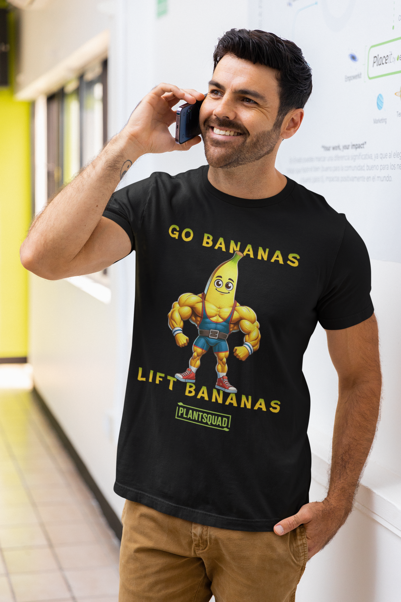 A Plantsquad Banana "Go Bananas Lift Bananas" - Unisex T-Shirt features a cartoon muscular banana wearing gym shorts, and boots. Above the banana, it says "GO BANANAS" and below it says "LIFT BANANAS". There is also a small green "plantsquad" logo at the bottom.