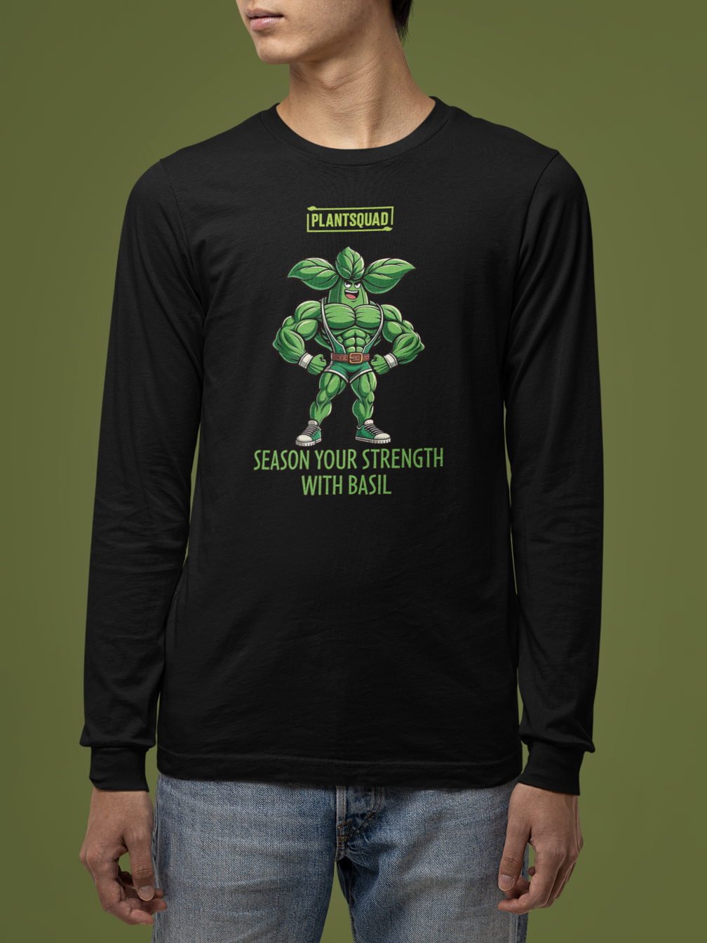 Black long-sleeve shirt with a graphic of a muscly basil cartoon in a green costume. Above the character, "PLANTSQUAD" is proudly displayed, and below, "SEASON YOUR STRENGTH WITH BASIL" appears in vibrant green letters. Perfect for fitness enthusiasts embracing a vegan lifestyle! Introducing the Plantsquad Basil "Season Your Strength With Basil" - Unisex Long Sleeve T-Shirt.