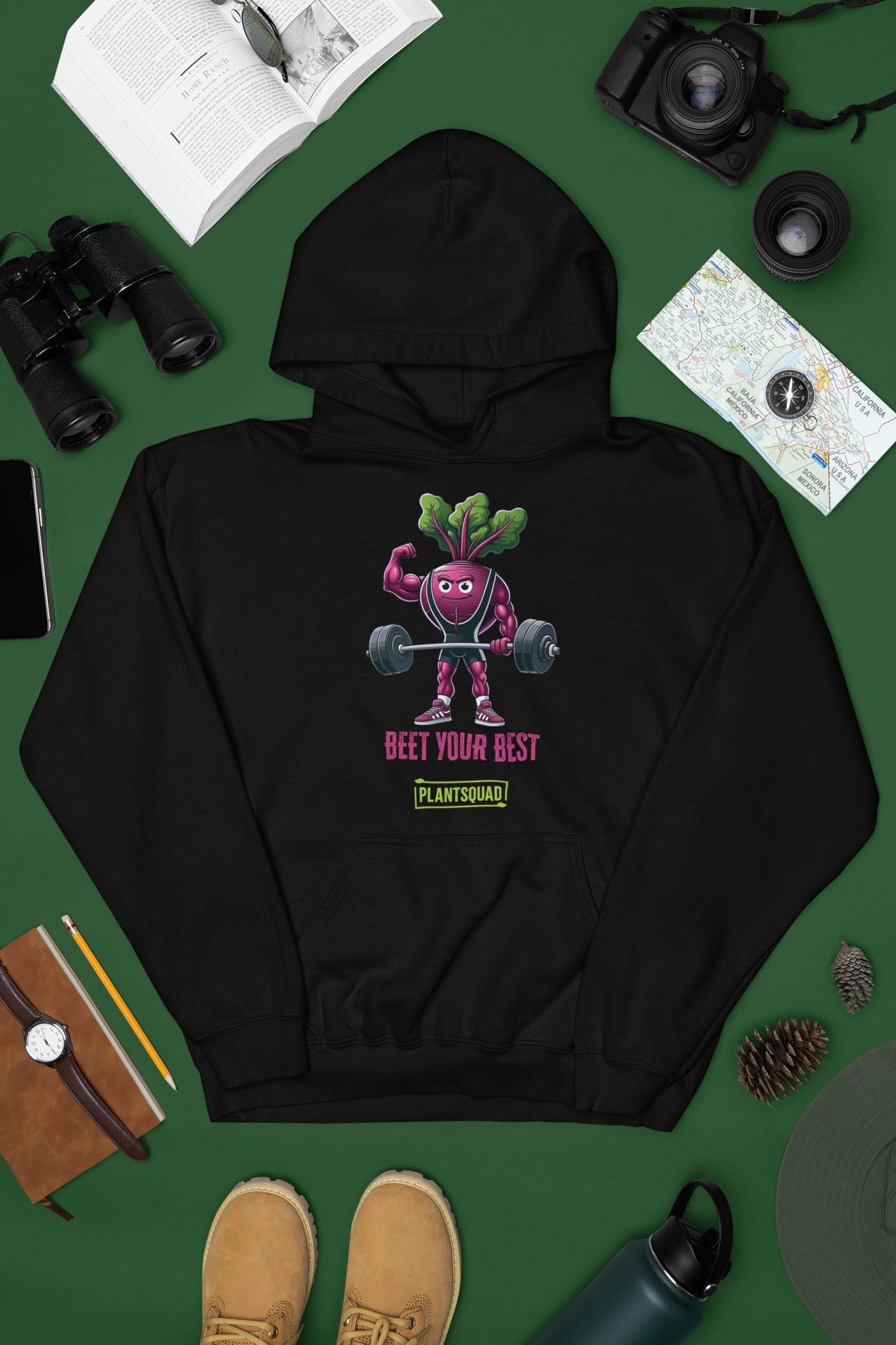 Enjoy the Plantsquad Beetroot "Beet Your Best" - Unisex Hoodie, a black hoodie made of cozy fabric featuring an illustrated beetroot lifting barbells, with leaves as hair, under the text "BEET YOUR BEST" in bold pink letters. Embrace your vegan lifestyle with the small green box below the beetroot character that reads "PLANTSQUAD.