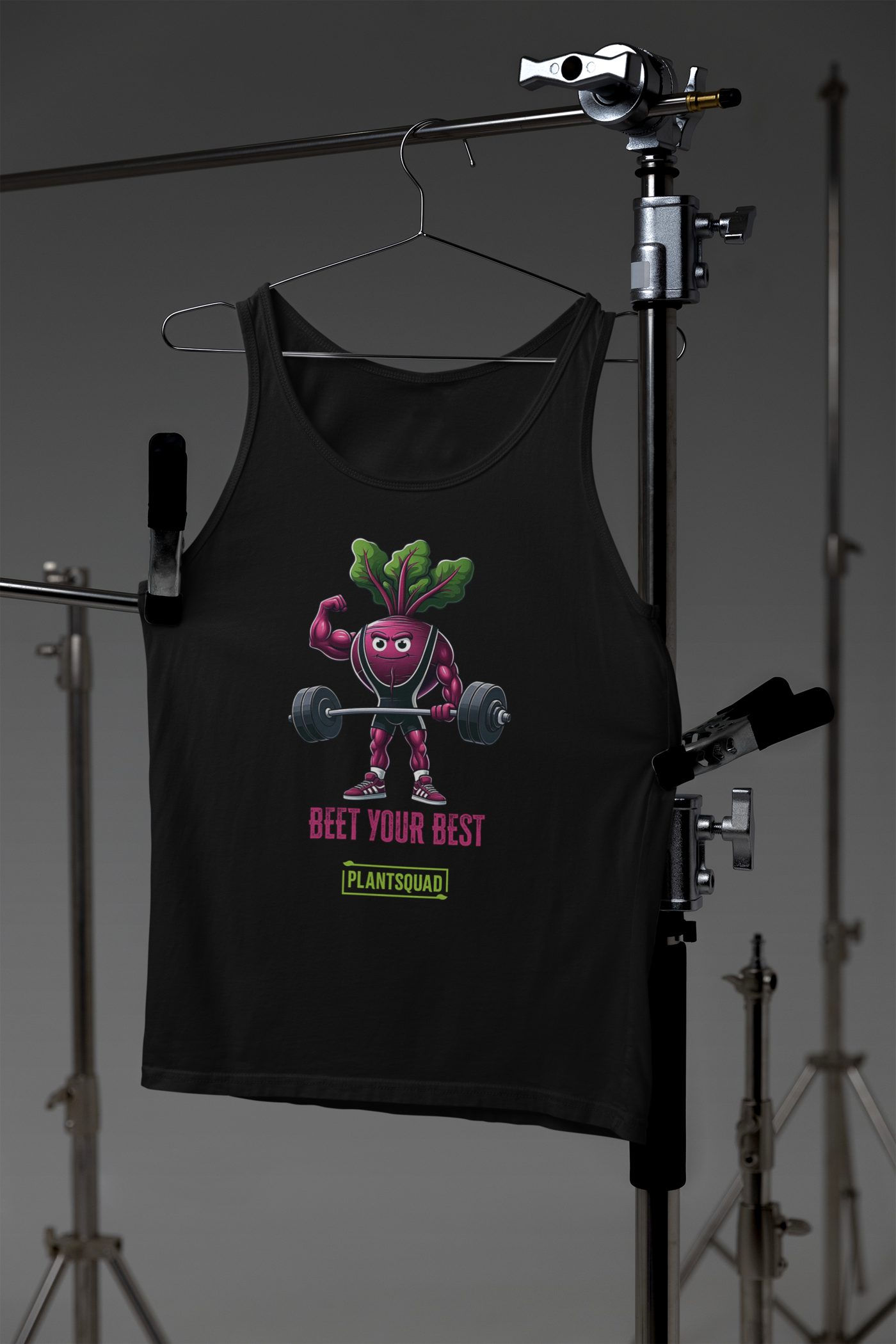 The Plantsquad Beetroot "Beet Your Best" - Unisex Tank Top features an illustration of a muscular beetroot character lifting a barbell. The text below the character reads "BEET YOUR BEST" in red and "PLANTSQUAD" in green. Perfect for gym enthusiasts embracing a plant-based lifestyle.