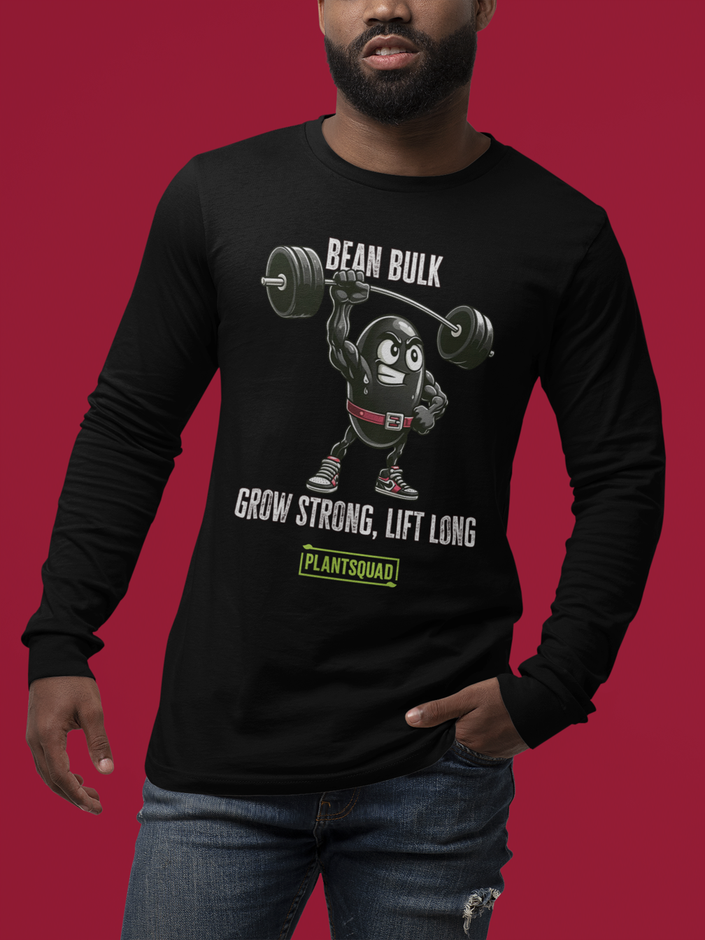 A black long-sleeve shirt, the Plantsquad Black Bean "Bean Bulk Grow Strong Lift Long" - Unisex Long Sleeve T-Shirt, features a cartoon bean character lifting weights with the text "Bean Bulk" above it. Below the character, the text reads "Grow Strong, Lift Long" and "PlantSquad." Perfect for fitness enthusiasts embracing a vegan lifestyle.