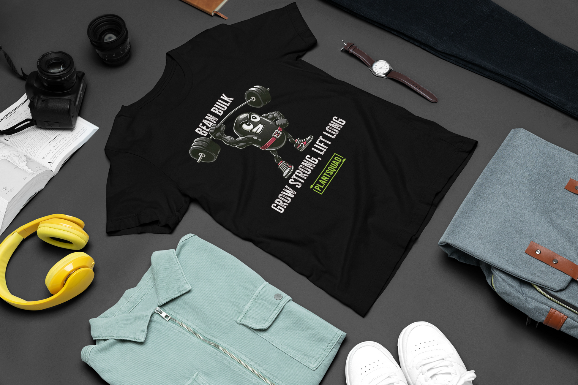 The Plantsquad Black Bean "Bean Bulk Grow Strong Lift Long" - Unisex T-Shirt features a muscular cartoon bean character lifting a barbell. The text above the character reads "Bean Bulk" and below it says "Grow Strong, Lift Long." Proudly show your loyalty to the Plantsquad with the word displayed in a green box at the bottom.