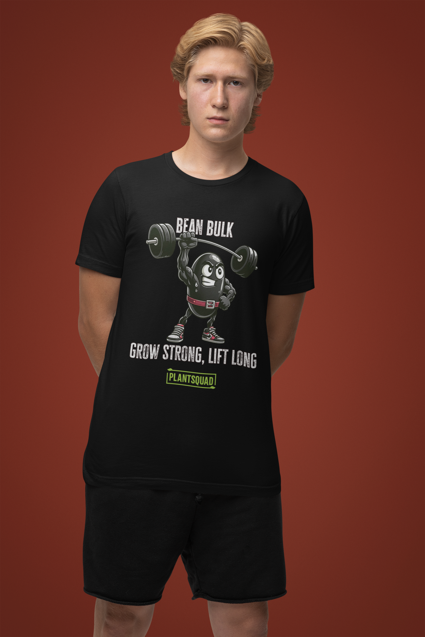 The Plantsquad Black Bean "Bean Bulk Grow Strong Lift Long" - Unisex T-Shirt features a muscular cartoon bean character lifting a barbell. The text above the character reads "Bean Bulk" and below it says "Grow Strong, Lift Long." Proudly show your loyalty to the Plantsquad with the word displayed in a green box at the bottom.