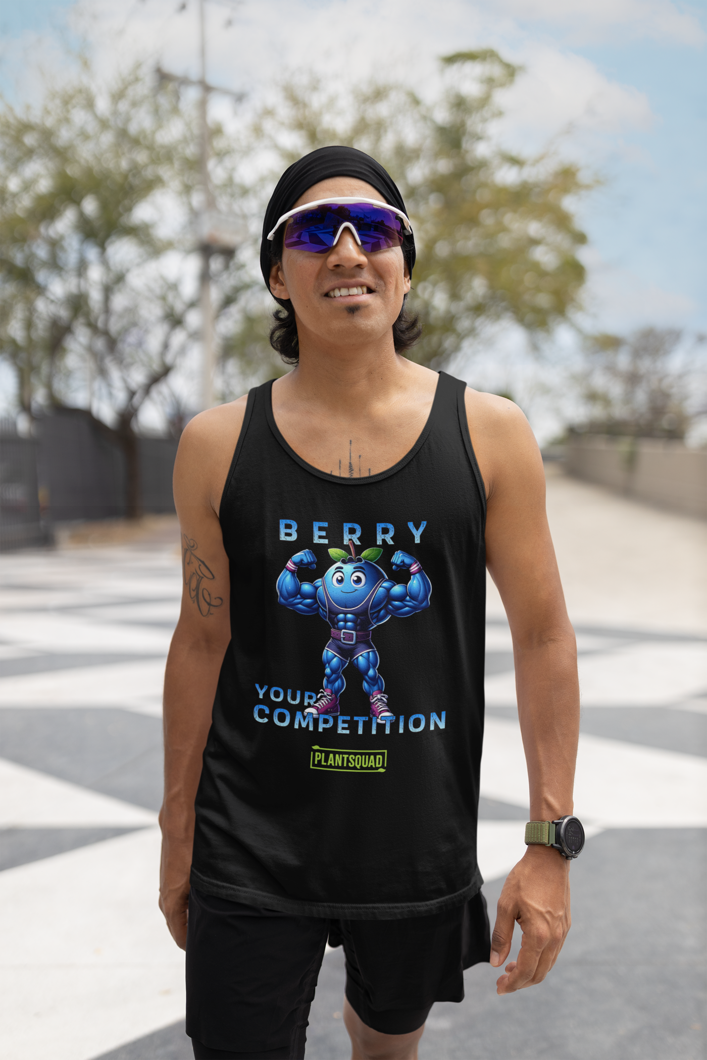 The Plantsquad Blueberry "Berry Your Competition" - Unisex Tank Top for gym enthusiasts features a muscular cartoon blueberry character flexing its arms. Above the character, text reads "BERRY," and below the character, text reads "YOUR COMPETITION." Made from breathable fabric, it also includes a green and yellow "PLANTSQUAD" logo at the bottom.