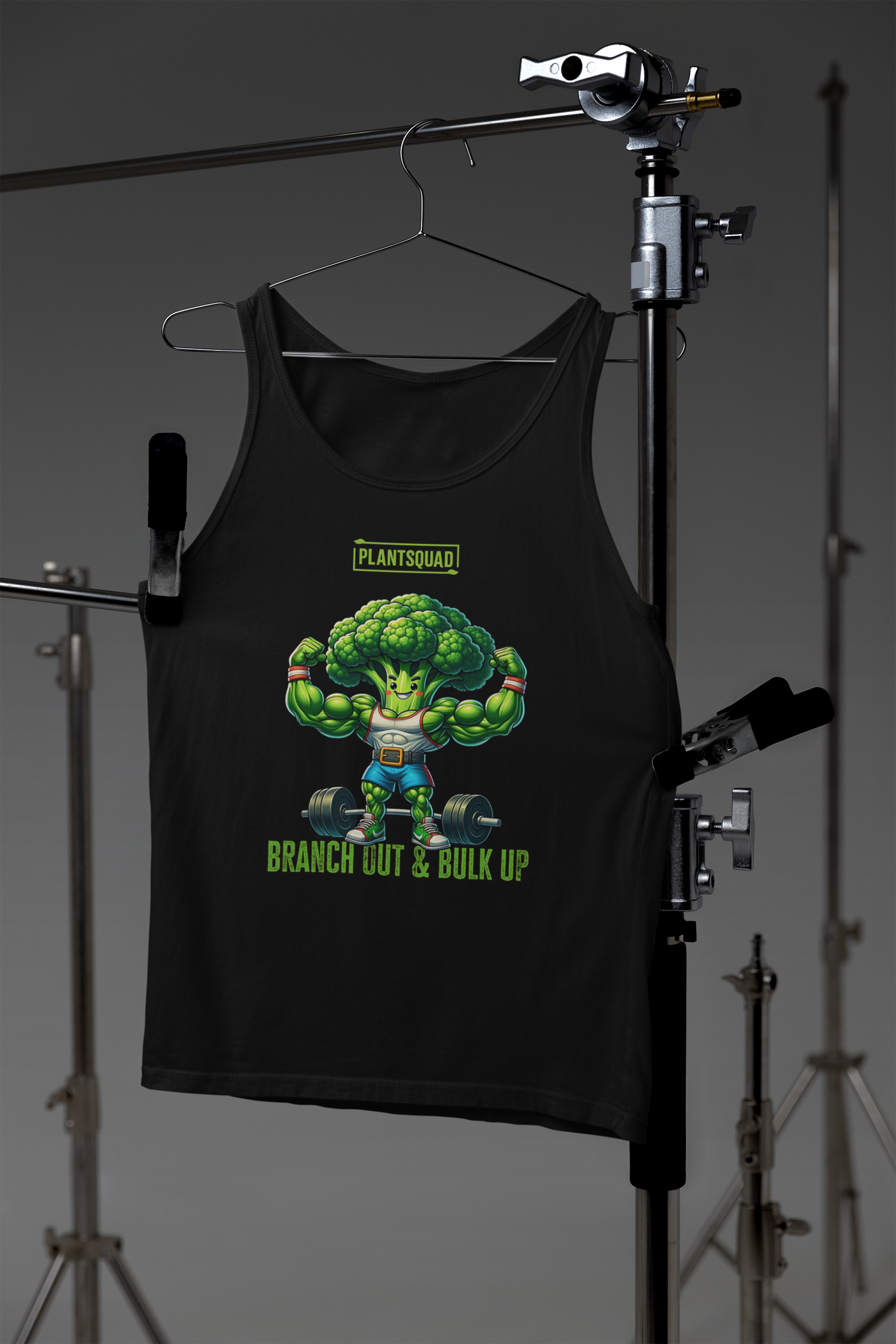 A Plantsquad Broccoli "Branch Out & Bulk Up" - Unisex Tank Top featuring a cartoon broccoli character with muscular arms lifting a barbell. Designed for vegan gym enthusiasts, it has the text "PLANTSQUAD" above the character and "BRANCH OUT & BULK UP?" below, all printed on breathable fabric ideal for your plant-based lifestyle.