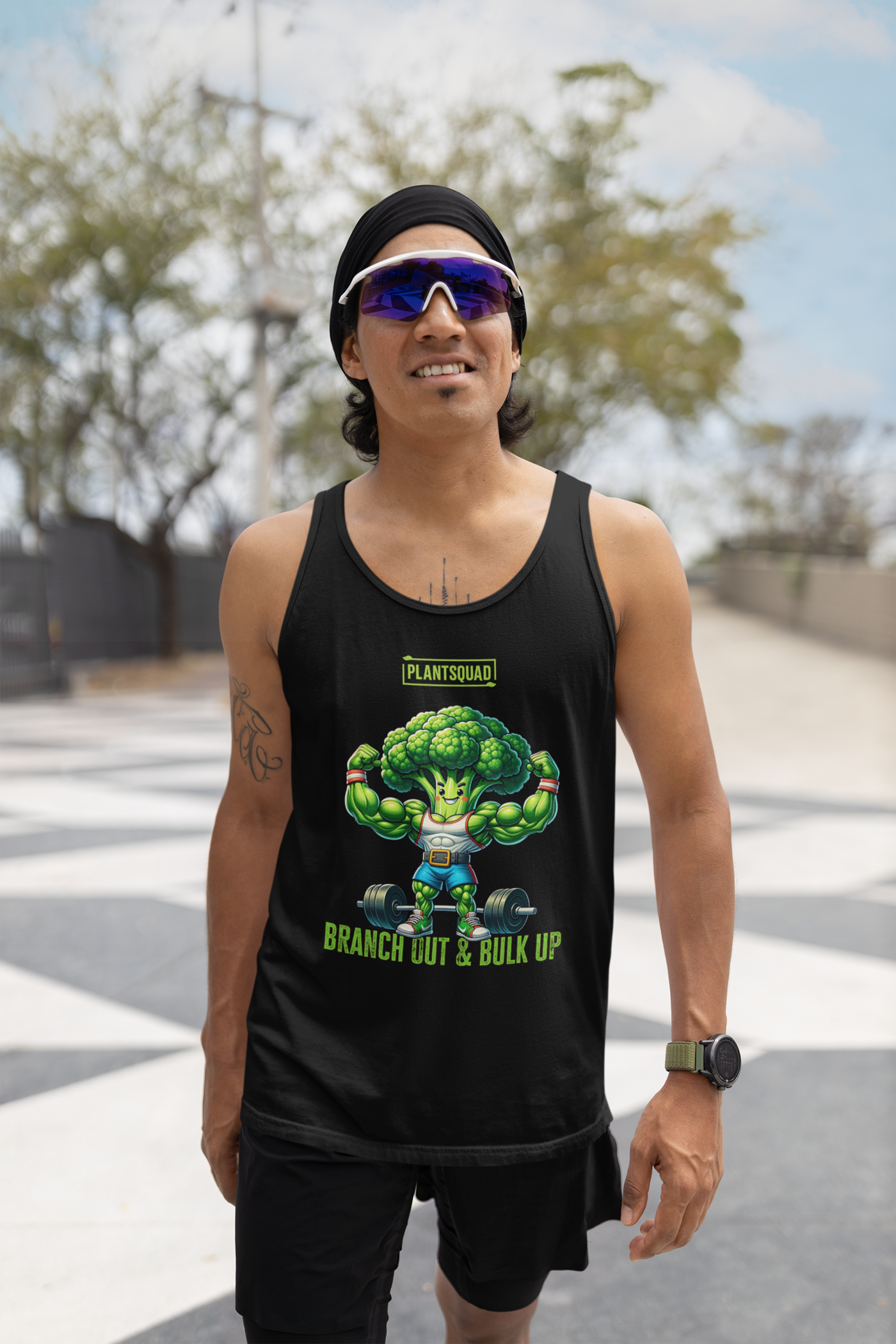 A Plantsquad Broccoli "Branch Out & Bulk Up" - Unisex Tank Top featuring a cartoon broccoli character with muscular arms lifting a barbell. Designed for vegan gym enthusiasts, it has the text "PLANTSQUAD" above the character and "BRANCH OUT & BULK UP?" below, all printed on breathable fabric ideal for your plant-based lifestyle.