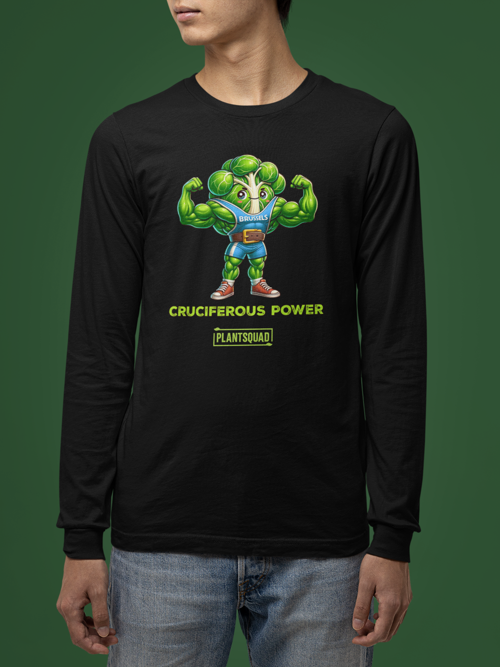 A Plantsquad Brussel Sprout "Cruciferous Power" - Unisex Long Sleeve T-Shirt featuring a muscly animated character resembling a brussel sprout, labeled "Bruulis" on its chest. The text below the character reads, "CRUCIFEROUS POWER" in yellow and "PLANTSQUAD" in green. Perfect for fans of vegan fitness and a plant-based lifestyle.