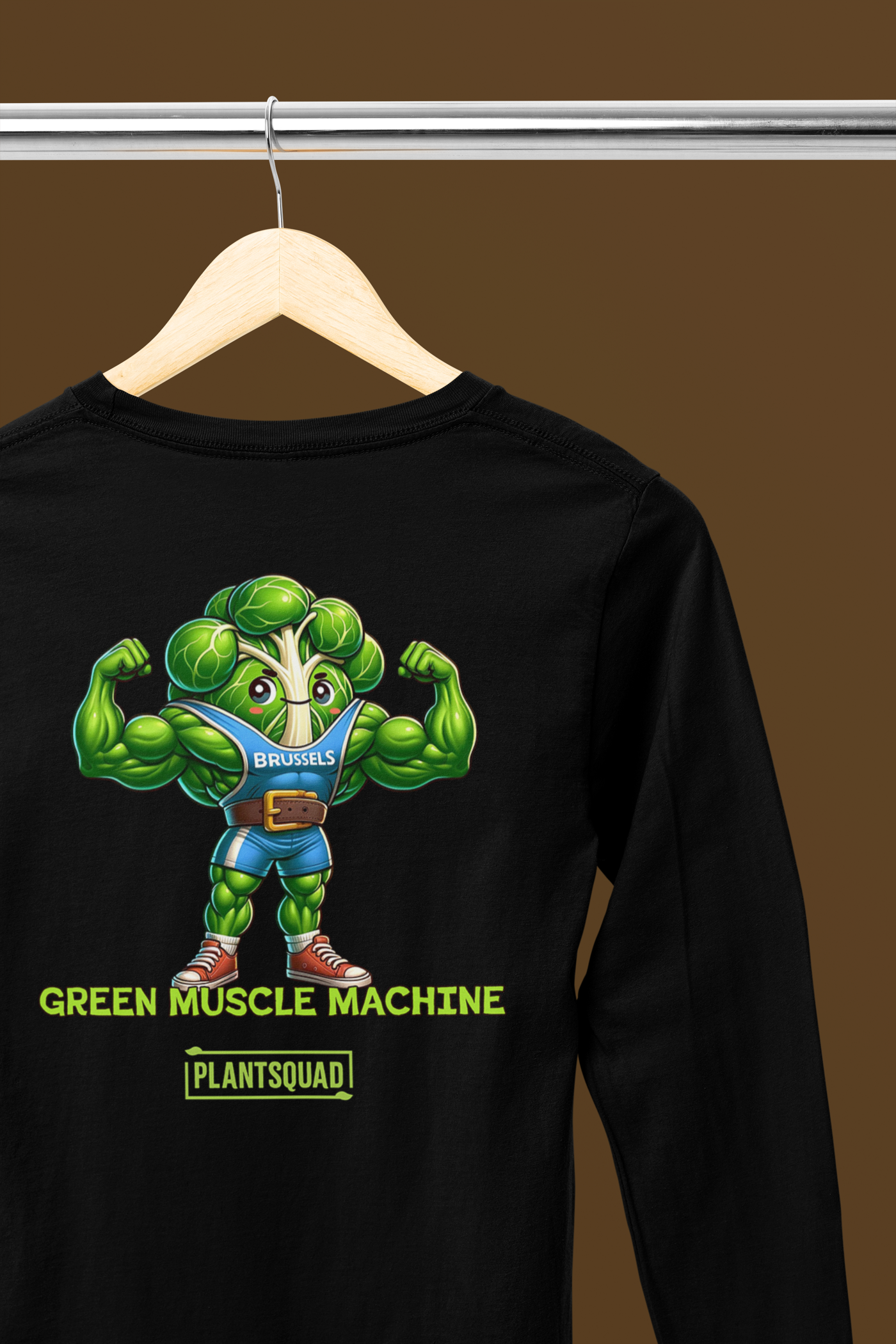 A Plantsquad Brussel Sprout "Green Muscle Machine" - Unisex Long Sleeve T-Shirt featuring a muscly Brussels sprout cartoon flexing its biceps. It wears a blue tank top labeled "BRUSSELS" and has text below that reads, "GREEN MUSCLE MACHINE" and "PLANTSQUAD." The design is vibrant and playful, making it perfect for those embracing a plant-based lifestyle.