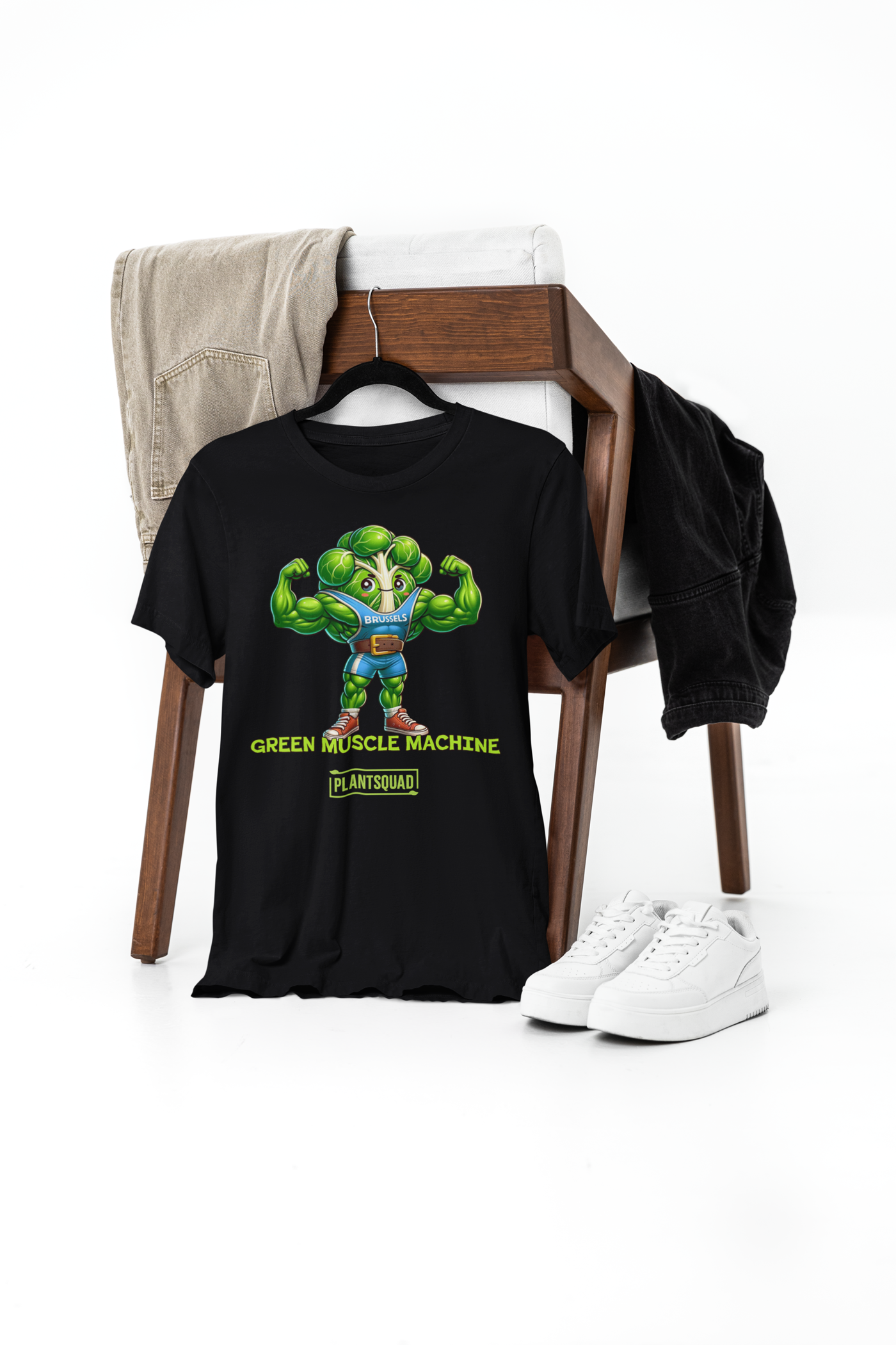 The Plantsquad Brussel Sprout "Green Muscle Machine" - Unisex T-Shirt showcases a muscular, anthropomorphic green broccoli character in a blue tank top flexing its arms. Below the character, the words "GREEN MUSCLE MACHINE" and "#PLANTSQUAD" are emblazoned in vibrant green text.