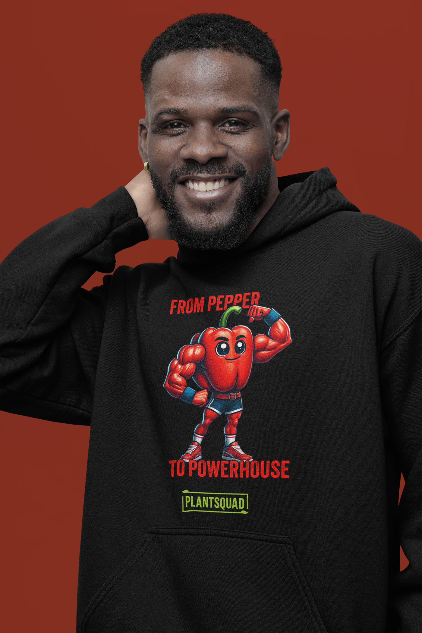 Plantsquad Capsicum "From Pepper To Powerhouse" - Unisex Hoodie featuring a cartoon image of a muscular red pepper wearing boxing gloves and shorts. The text above the character reads "FROM PEPPER TO POWERHOUSE" and below it, "PLANTSQUAD" is written on a green banner, celebrating the vegan lifestyle and plant-based power in weight lifting.