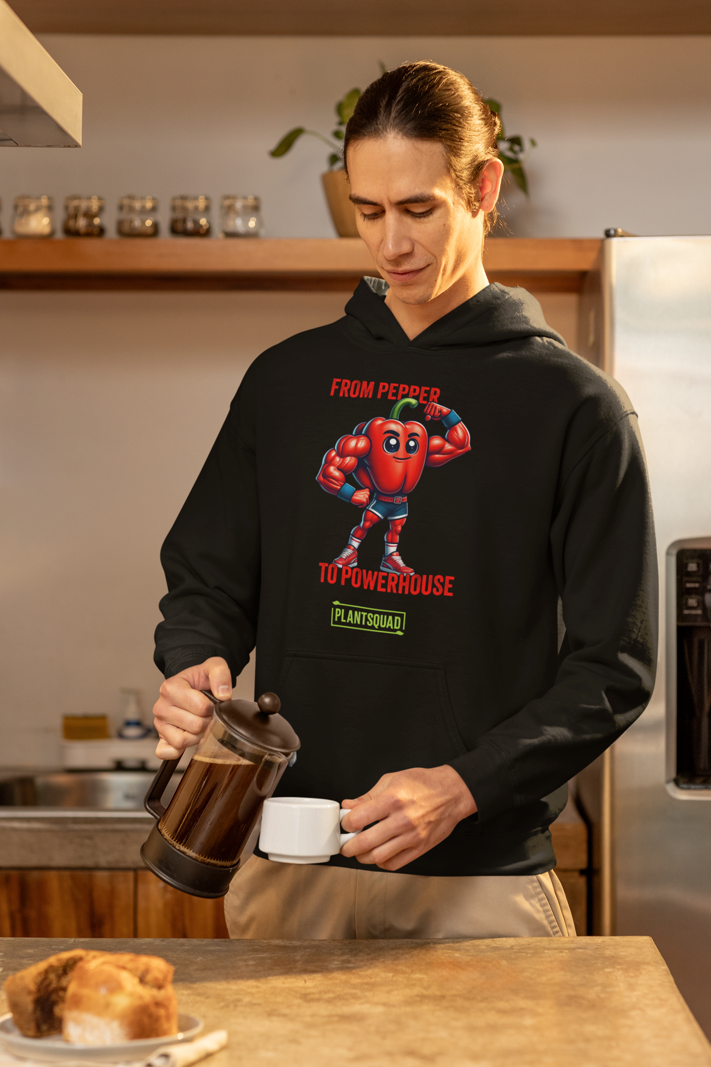 Plantsquad Capsicum "From Pepper To Powerhouse" - Unisex Hoodie featuring a cartoon image of a muscular red pepper wearing boxing gloves and shorts. The text above the character reads "FROM PEPPER TO POWERHOUSE" and below it, "PLANTSQUAD" is written on a green banner, celebrating the vegan lifestyle and plant-based power in weight lifting.