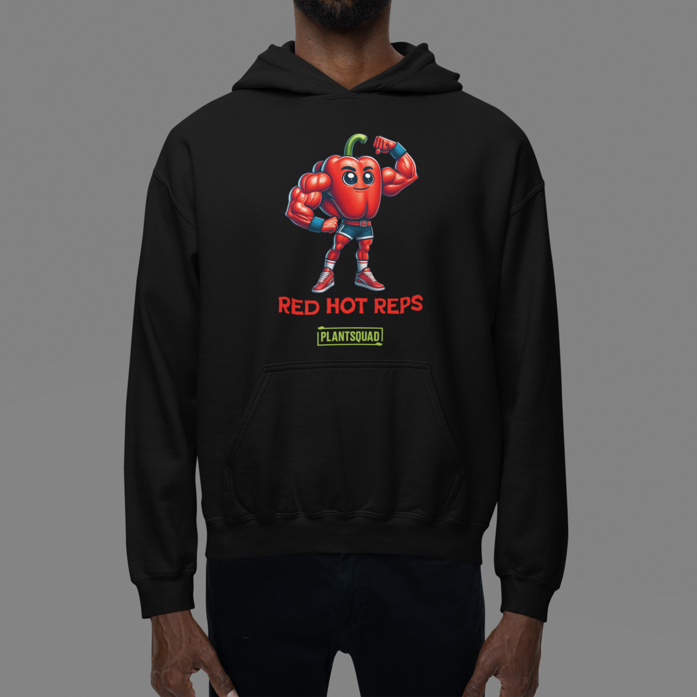 The Plantsquad Capsicum "Red Hot Reps" - Unisex Hoodie features a cartoon muscular red bell pepper character flexing its arms. The text "RED HOT REPS" is printed in red below the character, with "PLANTSQUAD" in green beneath it. Perfect workout clothing, the hoodie has a front pocket and drawstrings at the neck.