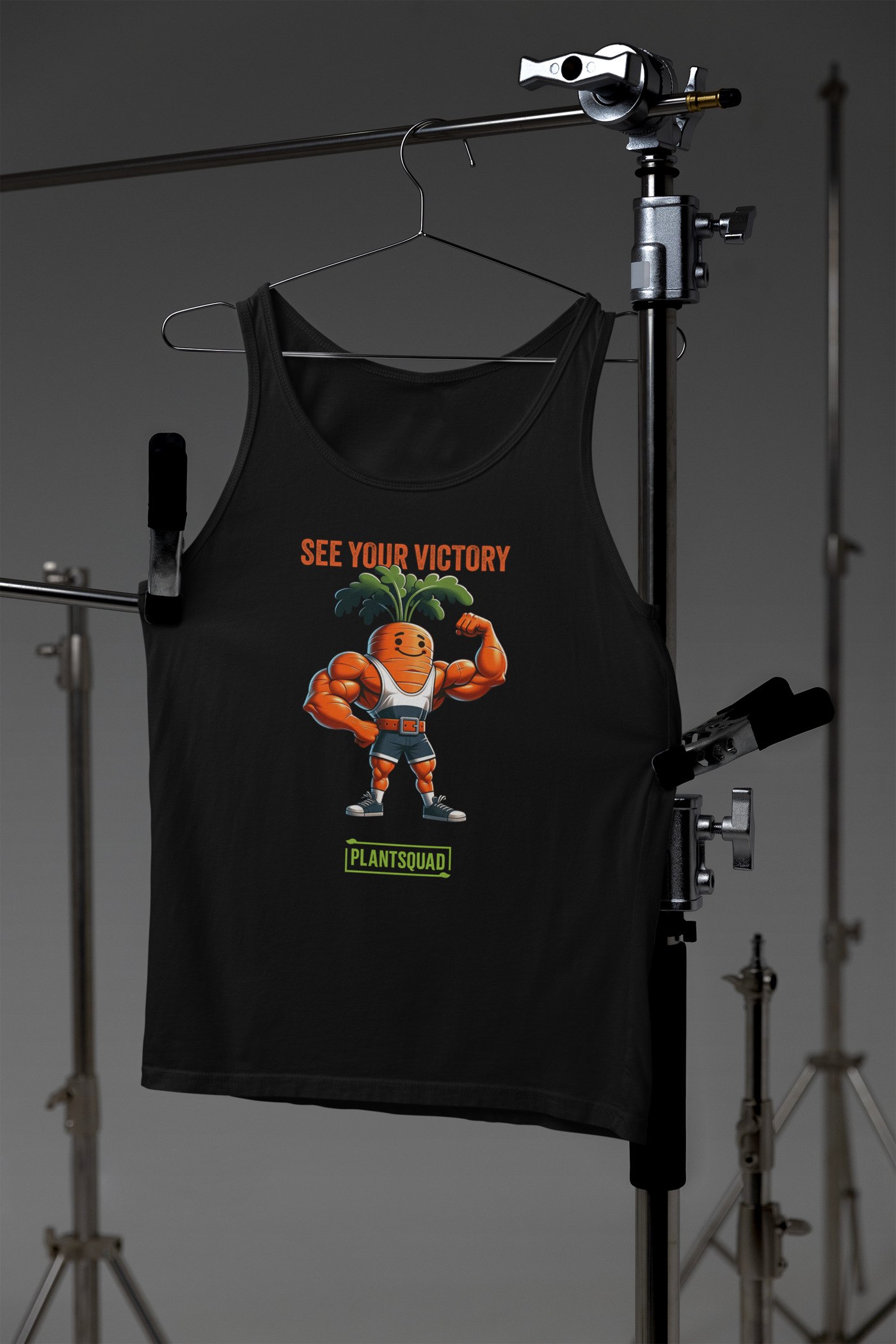 A Plantsquad Carrot "See Your Victory" - Unisex Tank Top featuring an illustration of a muscular carrot character flexing its arms, with leafy green hair. Above the character, it says "SEE YOUR VICTORY" in orange text, and below it, "PLANTSQUAD" is written in green text. Perfect for those embracing a plant-based lifestyle.