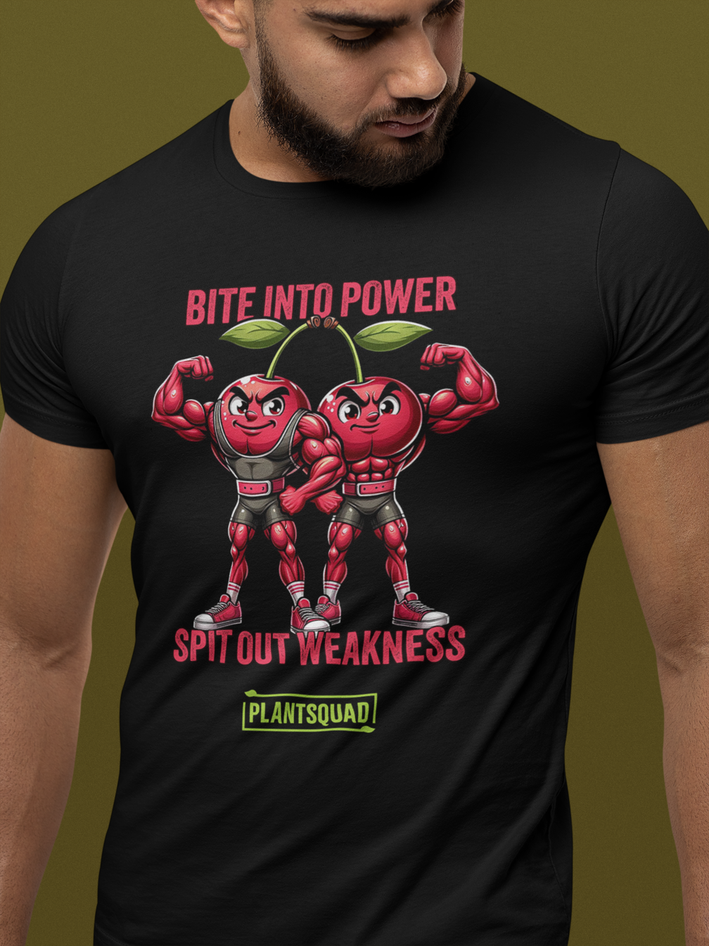 A black Plantsquad Cherries "Bite Into Power Spit Out Weakness" - Unisex T-shirt features two muscular cartoon cherries flexing their arms. Above them, pink text reads "Bite Into Power." Below them, white text reads "Spit Out Weakness." At the bottom, there's a green and yellow Plantsquad logo.