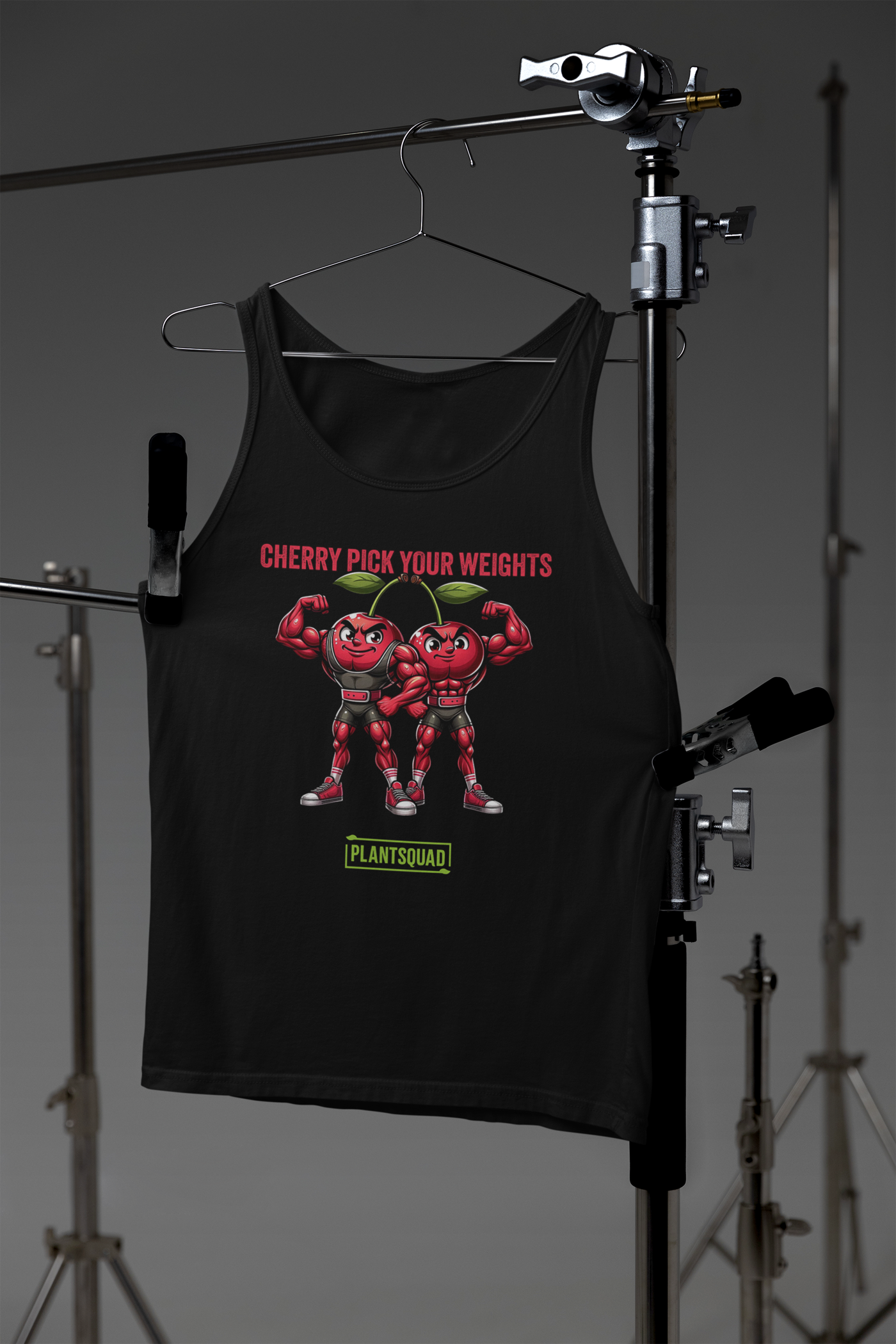 A black workout tank top featuring two muscular cartoon cherries flexing their biceps. Above them, red text reads "CHERRY PICK YOUR WEIGHTS," and below them, green text on a white background proudly states "Plantsquad." Perfect for vegans dedicated to fitness, this is the Plantsquad Cherries "Cherry Pick Your Weights" - Unisex Tank Top.