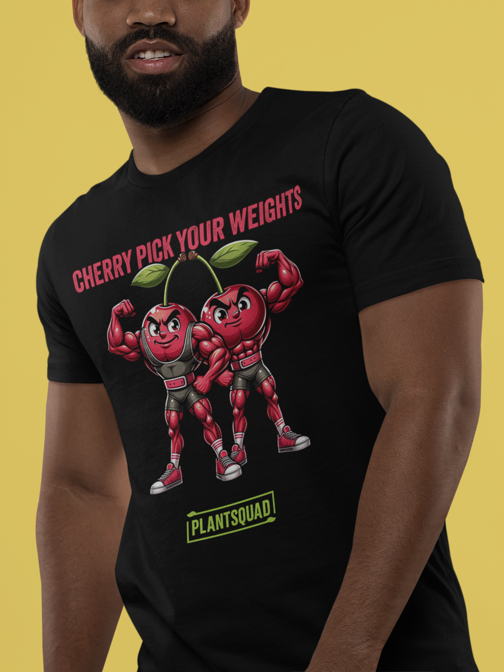 A Plantsquad Cherries "Cherry Pick Your Weights" - Unisex T-Shirt features two muscular cartoon cherries flexing their arms. Above them, red text reads, "CHERRY PICK YOUR WEIGHTS." Below the cherries, green text inside a box proudly displays, "PLANTSQUAD.