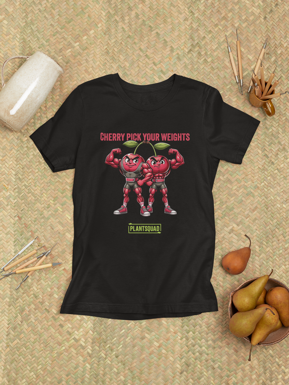 A Plantsquad Cherries "Cherry Pick Your Weights" - Unisex T-Shirt features two muscular cartoon cherries flexing their arms. Above them, red text reads, "CHERRY PICK YOUR WEIGHTS." Below the cherries, green text inside a box proudly displays, "PLANTSQUAD.