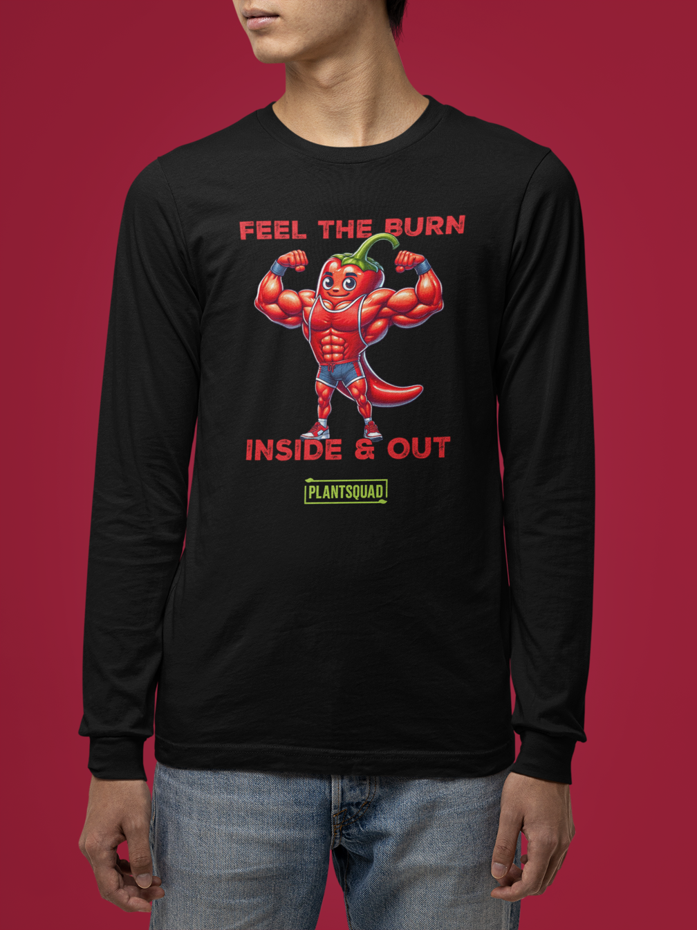 A black workout long-sleeve tee displays a muscular, anthropomorphic chili pepper character flexing its arms. The text above reads, "FEEL THE BURN" and below, "INSIDE & OUT." Perfect for a plant-based lifestyle, the Plantsquad Chilli "Feel The Burn Inside & Out" - Unisex Long Sleeve T-Shirt is printed at the bottom in a yellow-green box.