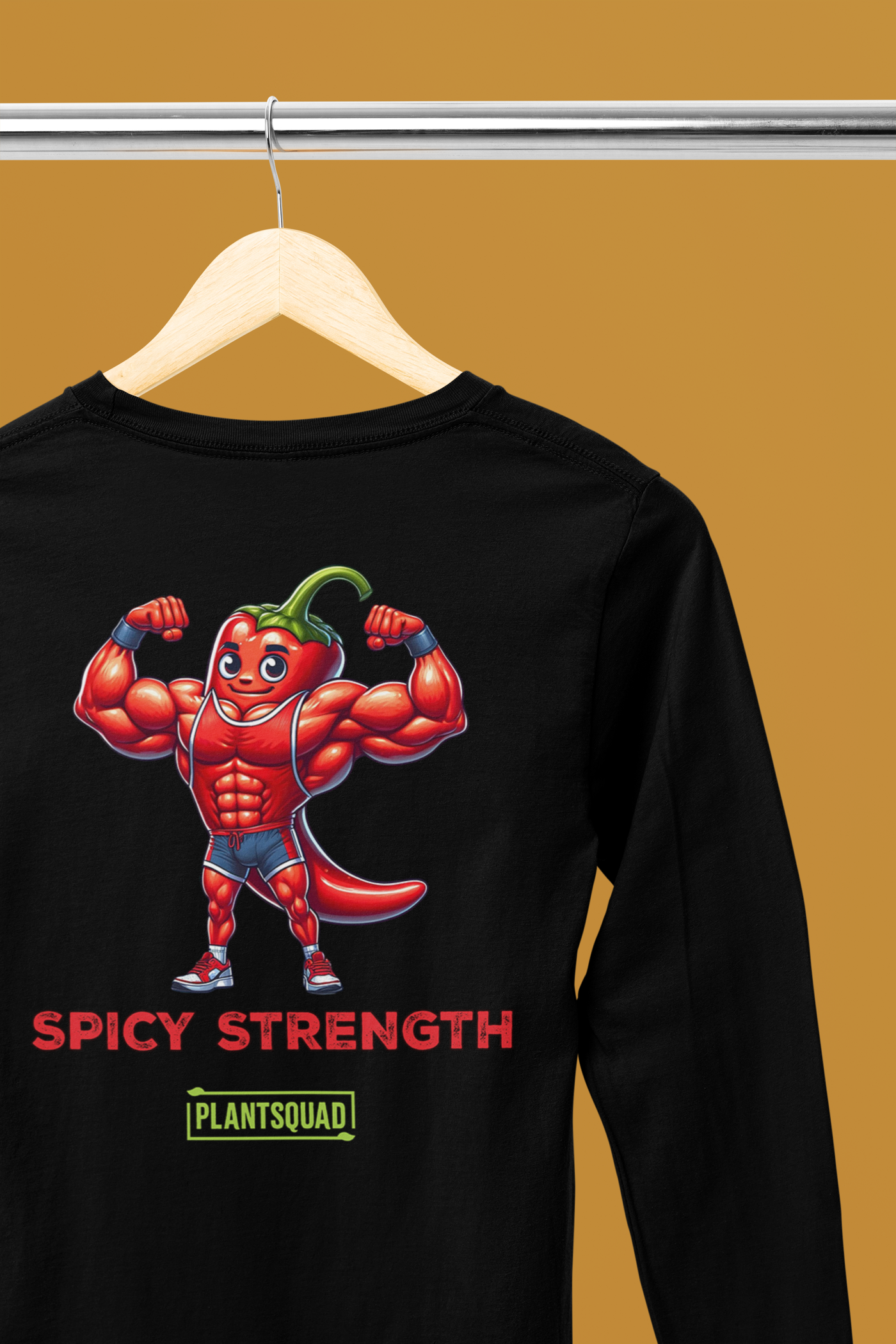 A Plantsquad Chilli "Spicy Strength" - Unisex Long Sleeve T-Shirt displaying a muscly chili cartoon character with muscles, flexing its arms. Below the character, the text reads "SPICY STRENGTH" and "PLANTSQUAD" in red and green fonts, respectively—perfect for fitness enthusiasts embracing a vegan lifestyle.