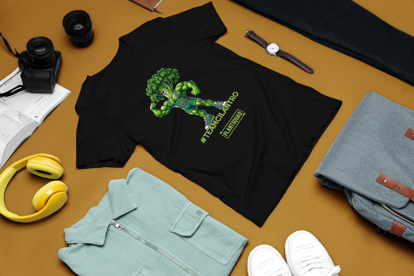 A Plantsquad Cilantro "Team Cilantro" - Unisex T-Shirt showcasing a cartoon character with a broccoli head and muscular green body. The character, dressed in a green singlet and flexing one arm, proudly displays the text "#TEAMCILANTRO" below, alongside the iconic "plant squad" logo.