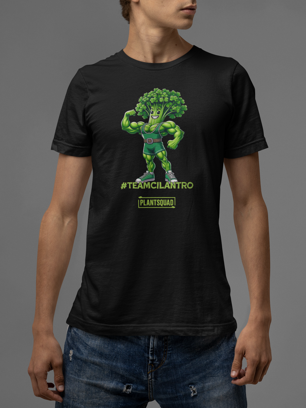 A Plantsquad Cilantro "Team Cilantro" - Unisex T-Shirt showcasing a cartoon character with a broccoli head and muscular green body. The character, dressed in a green singlet and flexing one arm, proudly displays the text "#TEAMCILANTRO" below, alongside the iconic "plant squad" logo.